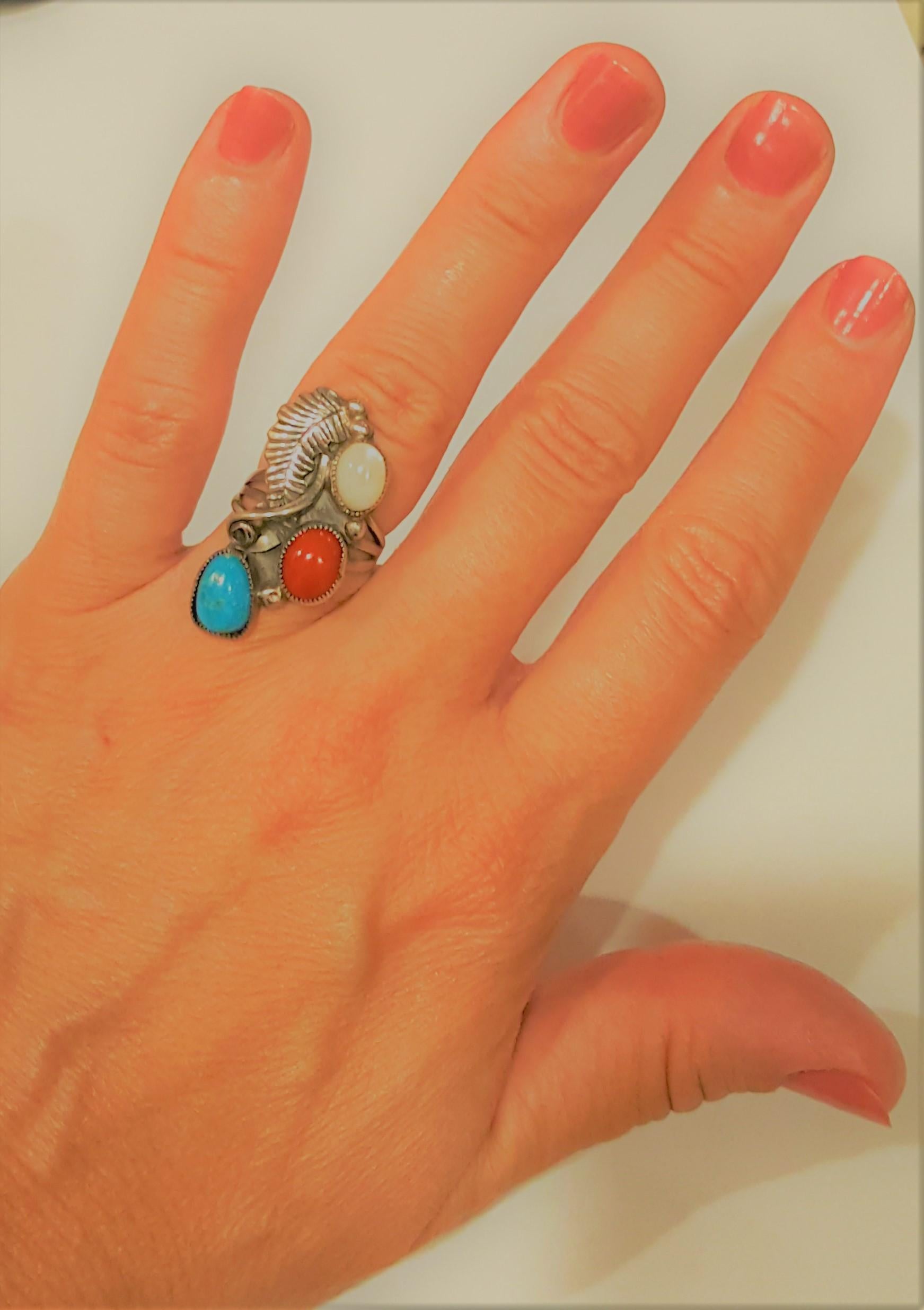 Einzigartiger Silberring der amerikanischen Ureinwohner mit Türkis, Karneol und weißem Edelstein, akzentuiert mit einem Feder- und Schneckenmuster. Der Ring ist 31mm x 16mm an der Spitze des Rings und die Seiten verjüngen sich von 7mm auf 3mm an der