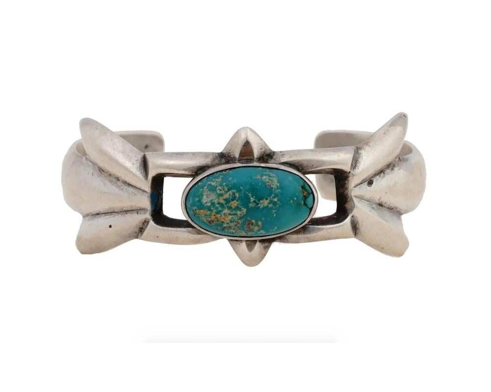 An old Pawn Navajo or Hopi, Sandcast Native American Sterling Silver Bangle with a turquoise cabochon accent. The hallmark is scratched in cursive and it is Maria 29- E52E911. This piece of jewelry is very similar to others created and signed by