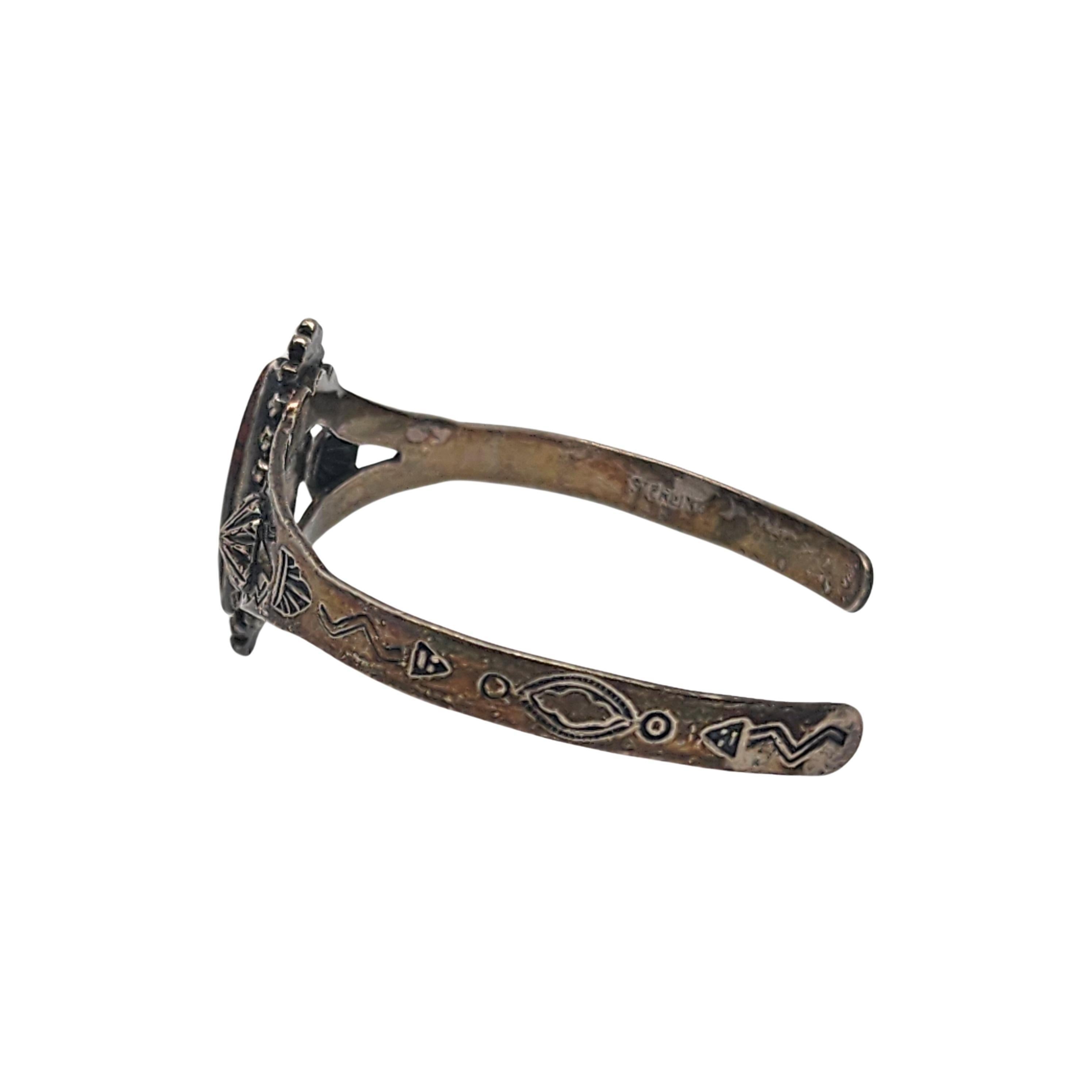 Sterling silver and brown turquoise cuff bracelet by Native American artisan.

This bracelet features a bezel set brown turquoise marquis shaped stone surrounded by a dotted frame design. Stamped accents adorn the bracelet.

Weighs approx 10.6g,