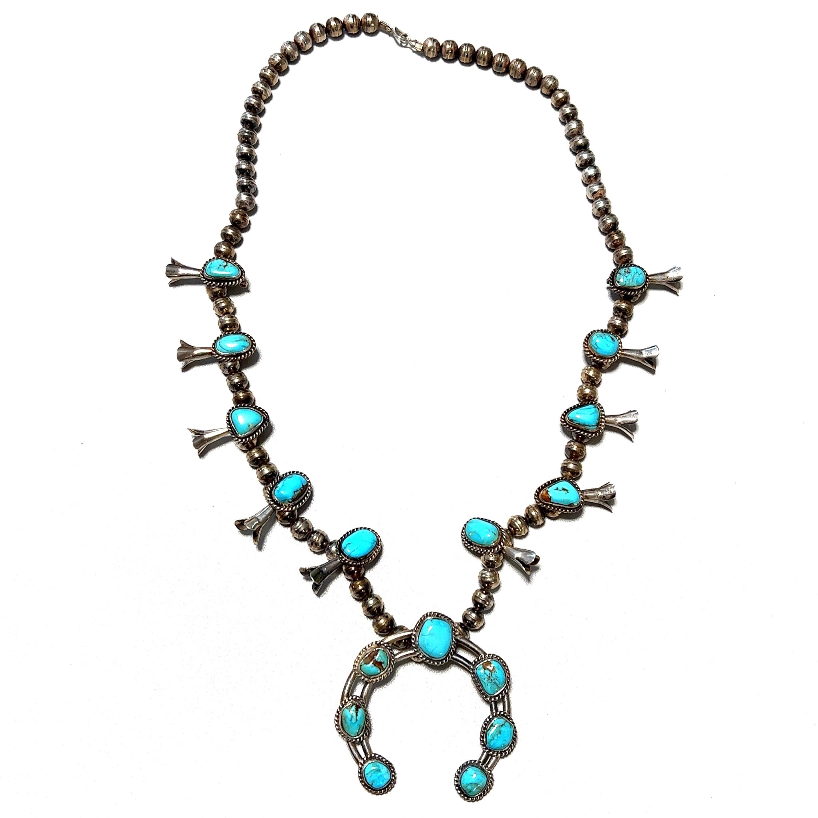 Simply Beautiful! Highly desirable Large Native American original Old Pawn Navajo Squash Blossom Necklace. Featuring 17 Turquoise Sleeping Beauty stations with a large center horseshoe Pendant. Measuring approx. 25