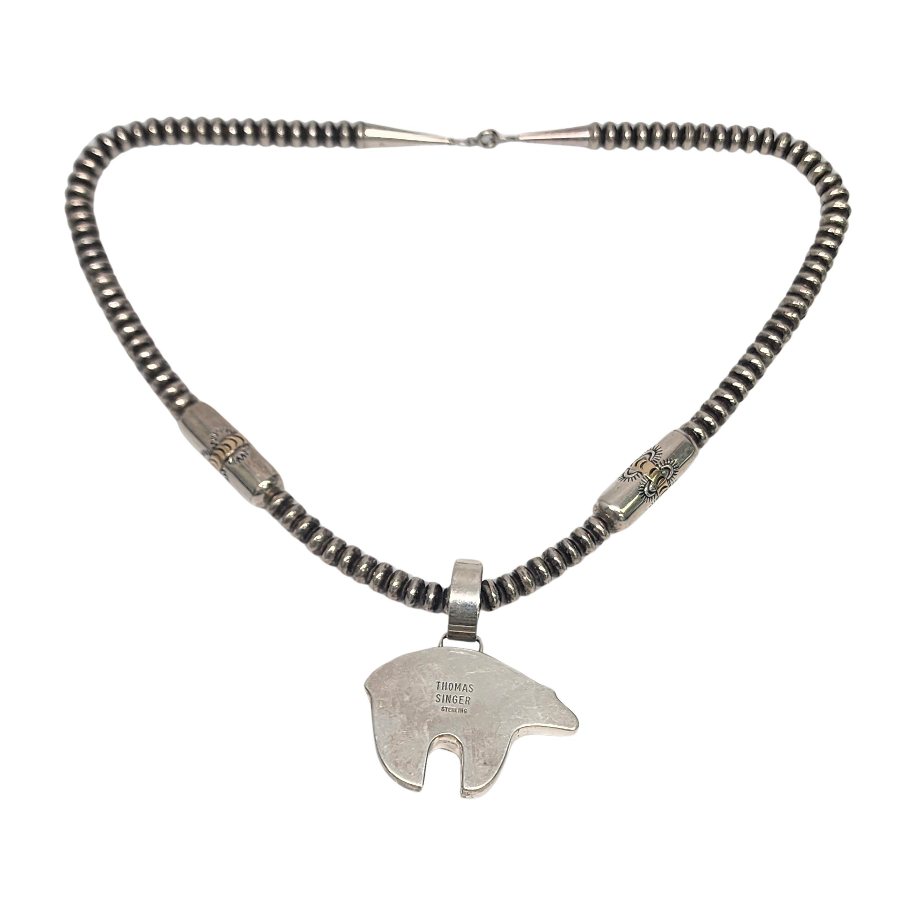 Sterling silver with gold accent saucer and barrel bead necklace by Native American artisan Joe Tortalita, with bear pendant by Native American artisan, Thomas Singer.

Beautiful saucer and barrel bead necklace by Santo Domingo Kewa artisan Joe