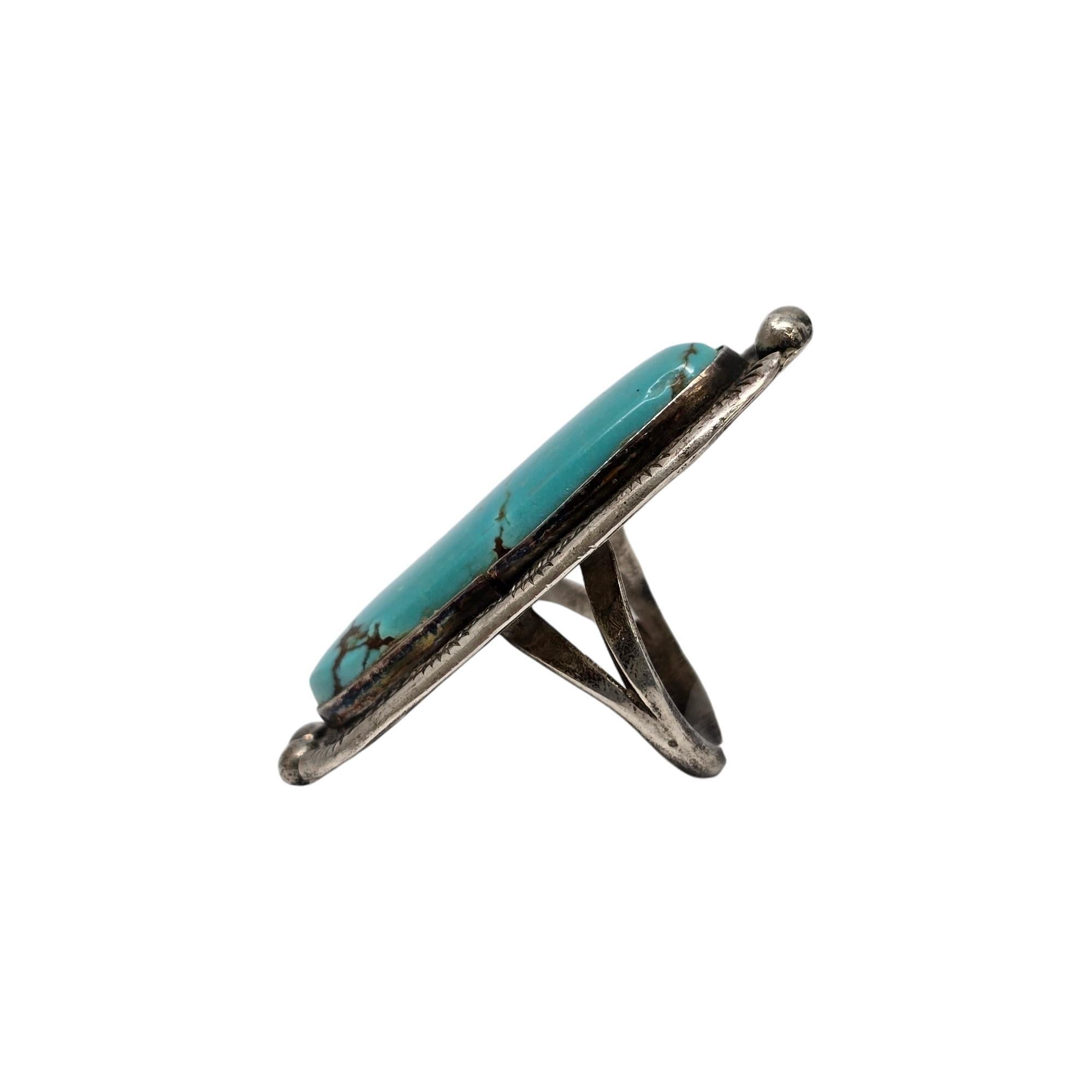 Sterling silver large turquoise ring by Native American artisan.

Size 7

This piece features a large oblong light blue turquoise with brown veining, bezel set with stamped and beaded accents around the stone.

Weighs approx 15.3g, 9.8dwt

Measures