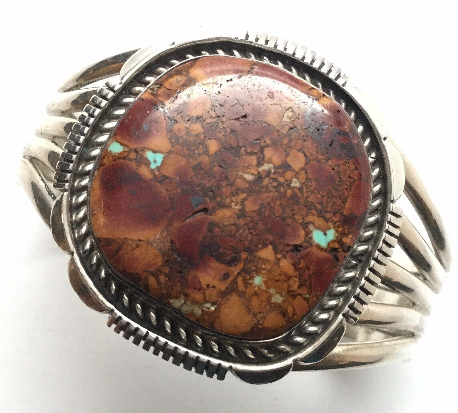 Native American sterling silver cuff bracelet with natural ocean jasper of red and turquoise.

Marked: Sterling,
Piece has artisan initials, but hard to see due in being blocked by band.

Measures: 5 1/2