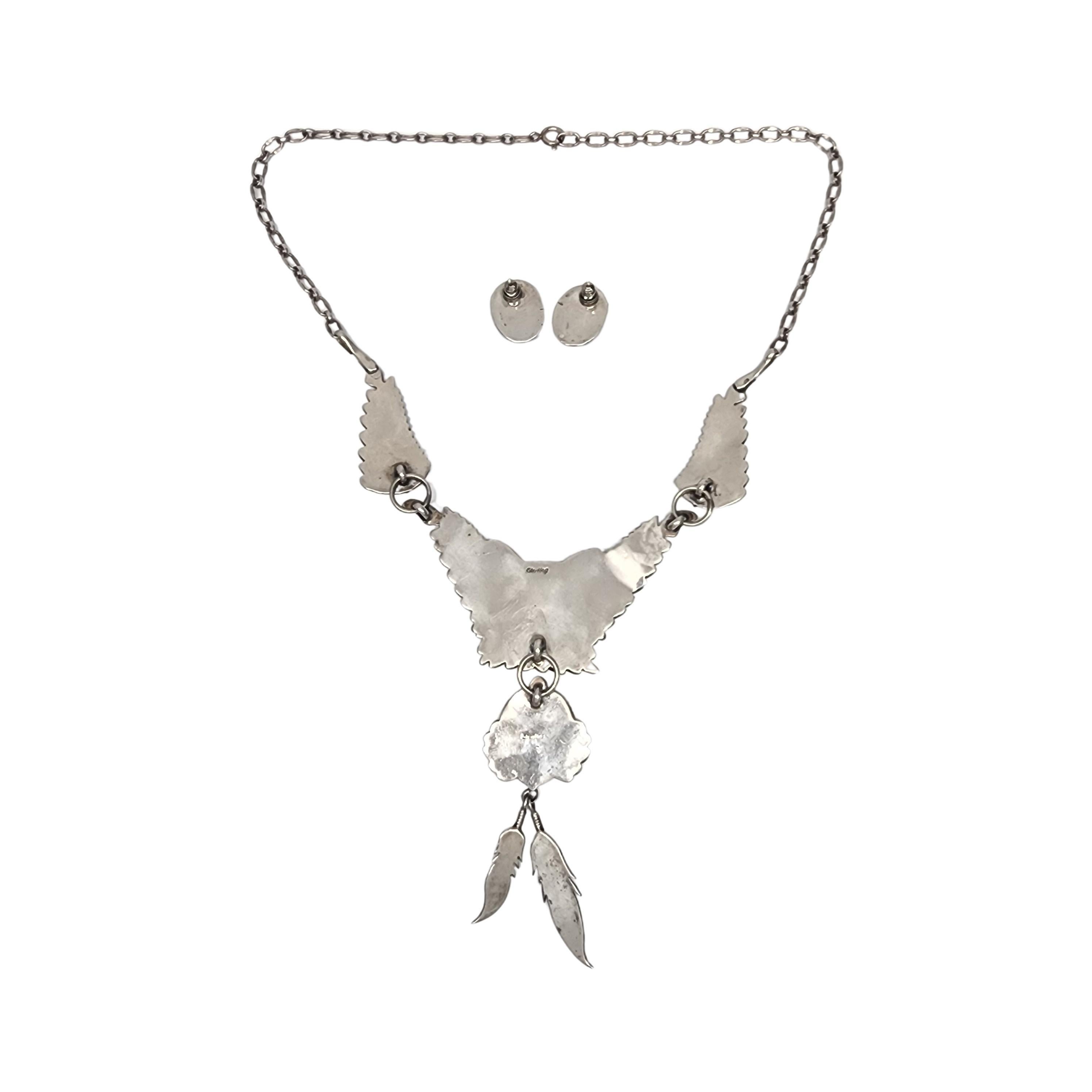 Native American sterling silver and pink shell feather necklace and earrings set.

Beautiful iridescent pink shells adorn this bib necklace featuring feather design and feather dangles. Matching oval saw-tooth bezel set pink shell earrings.

Weighs