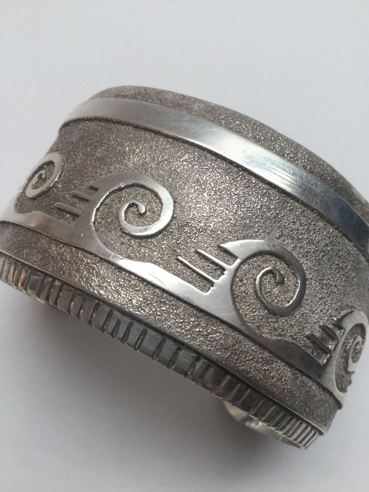 Native American sterling silver rolling waves textured cuff bracelet by T.

Marked: Sterling, T

Measures: 5 3/4