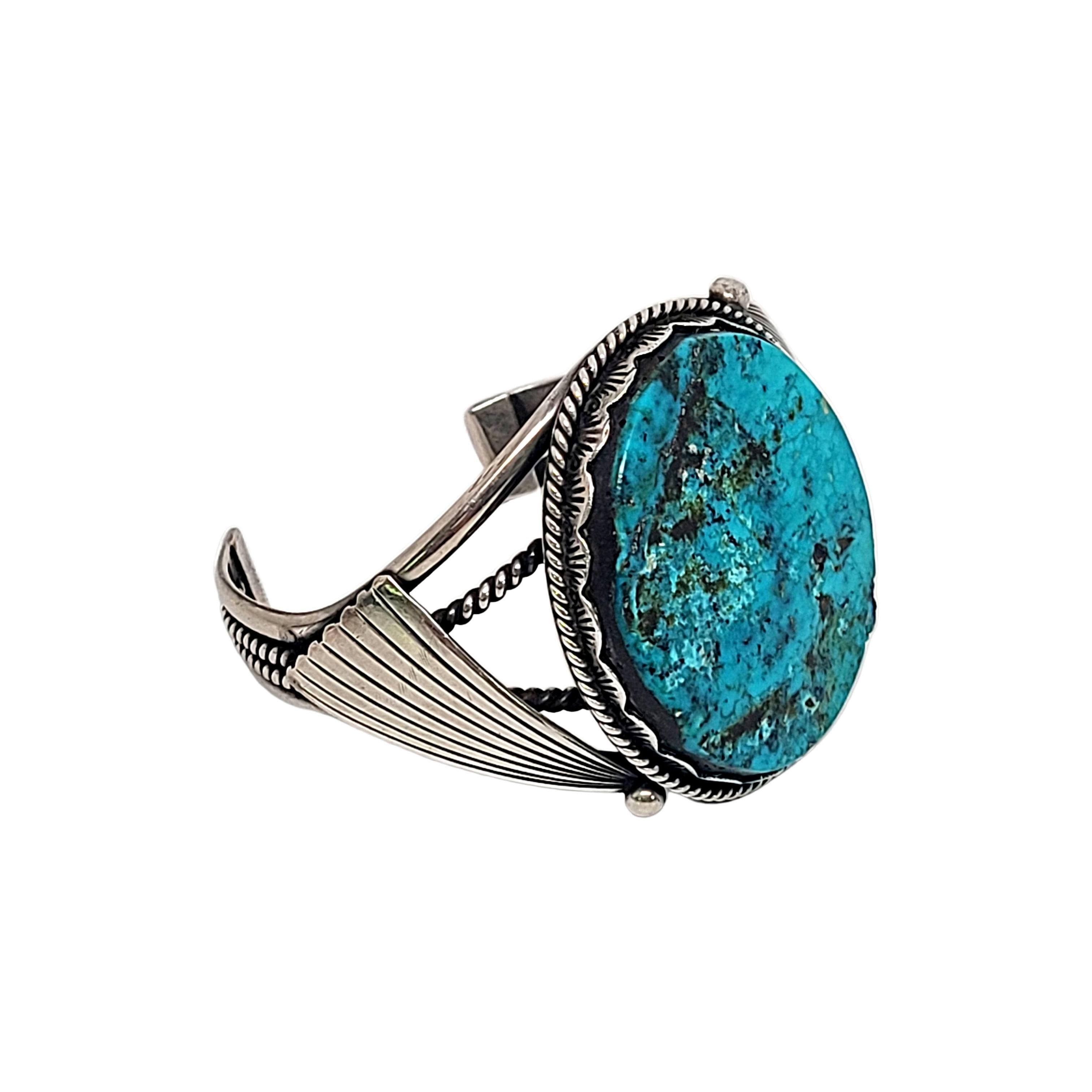 Sterling silver and turquoise cuff bracelet by Native American artisan.

Bezel set large oval shaped turquoise stone with rope design, stamp and open-work sides.

Measures approx 6 1/2