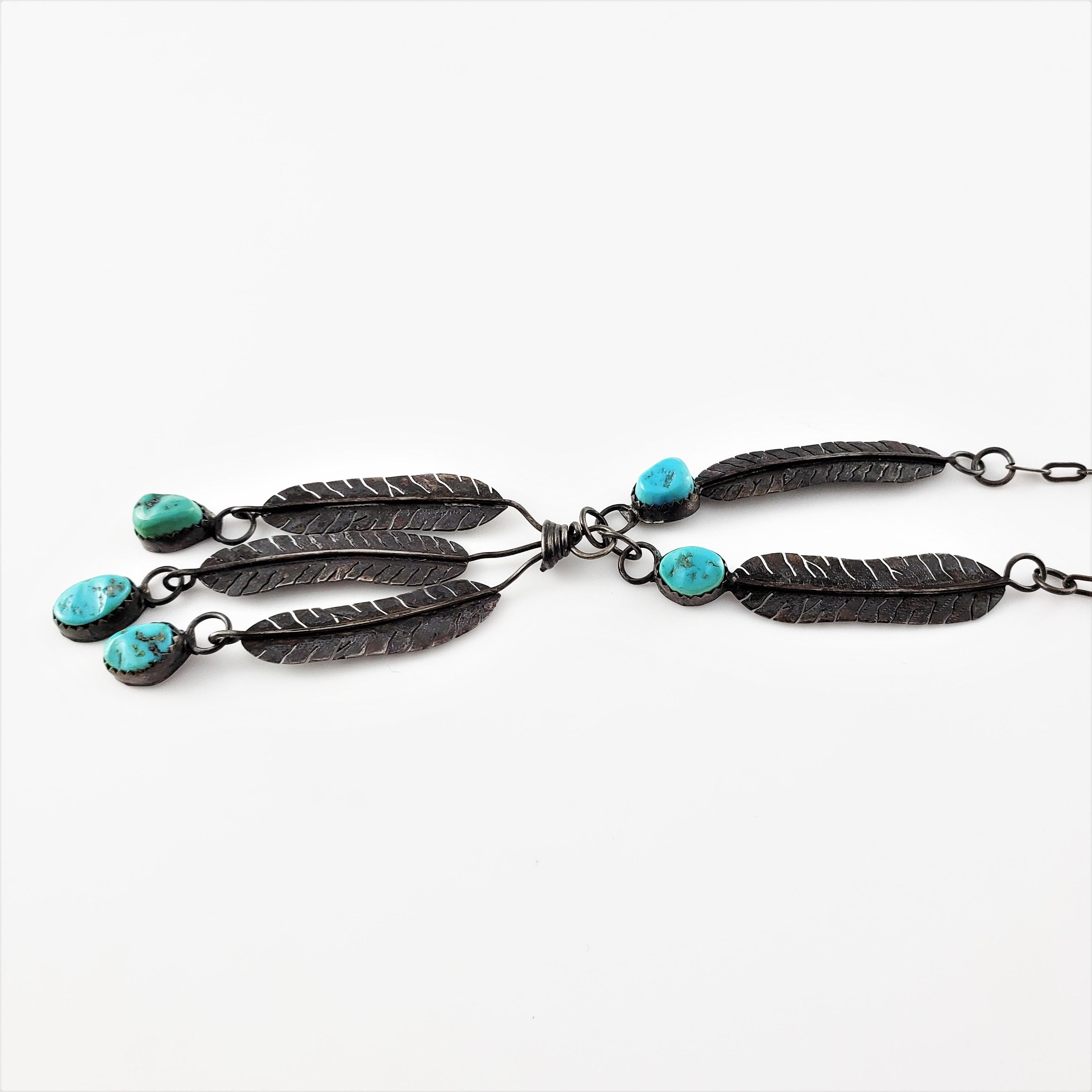 Vintage Native American Sterling Silver Turquoise Feather Dangle Pendant Necklace-

This lovely Native American dangling feather necklace features five turquoise stones (approximately 8 mm each) set in sterling silver.

Size: 16 inches -