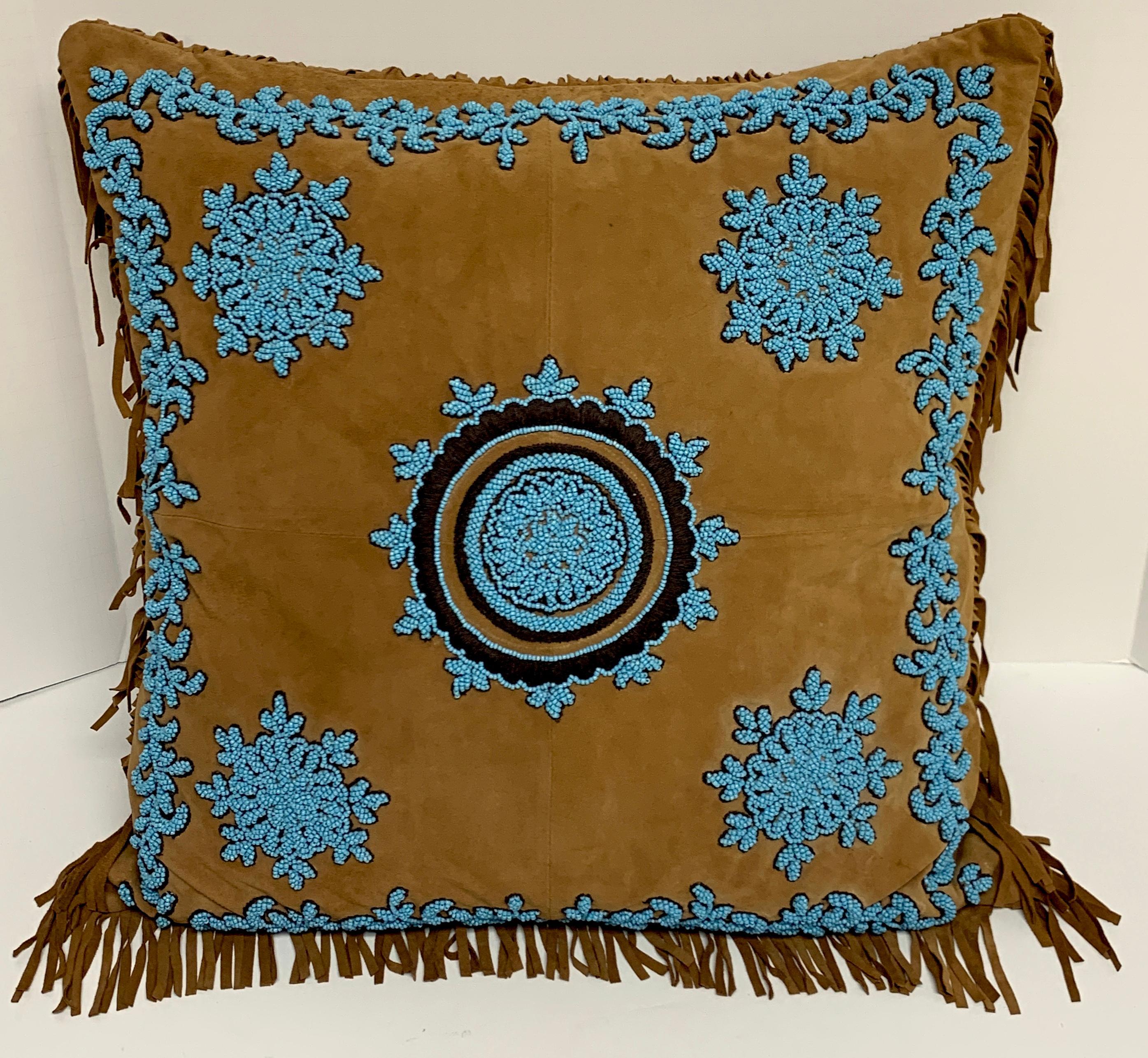 Native American style suede pillow with turquoise glass beadwork, luxurious deerskin/ suede, with intricate beadwork medallions and borders. Down filled with a 2.5 inch leather fringe.
The pillow measures: 18” H x 17” W with a 2.5 inch fringe