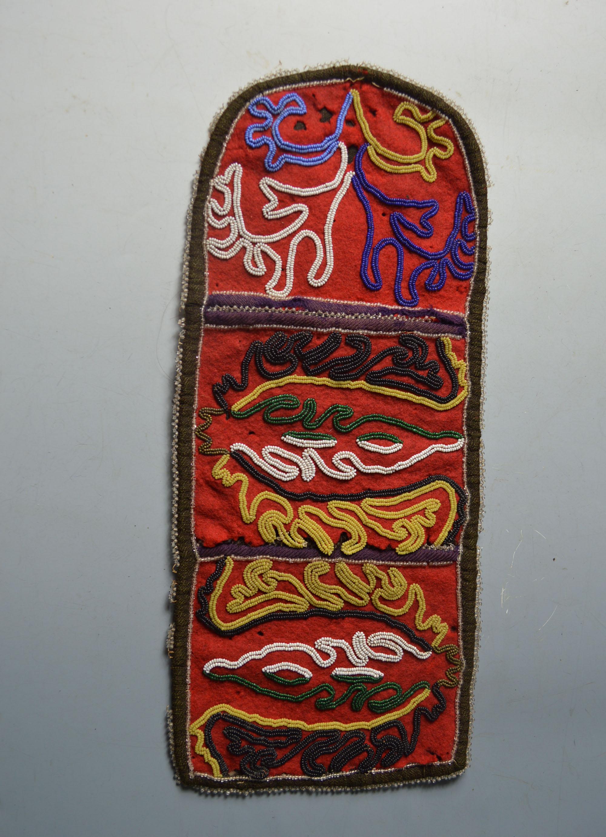 Native American Rare Tlingit Beaded pouch or wall pocket
Northwest Coast America
Cloth and colored glass beads, with three panels of foliage decoration,
Period late 19th century,
34 cm long.
Condition: Minor damage.