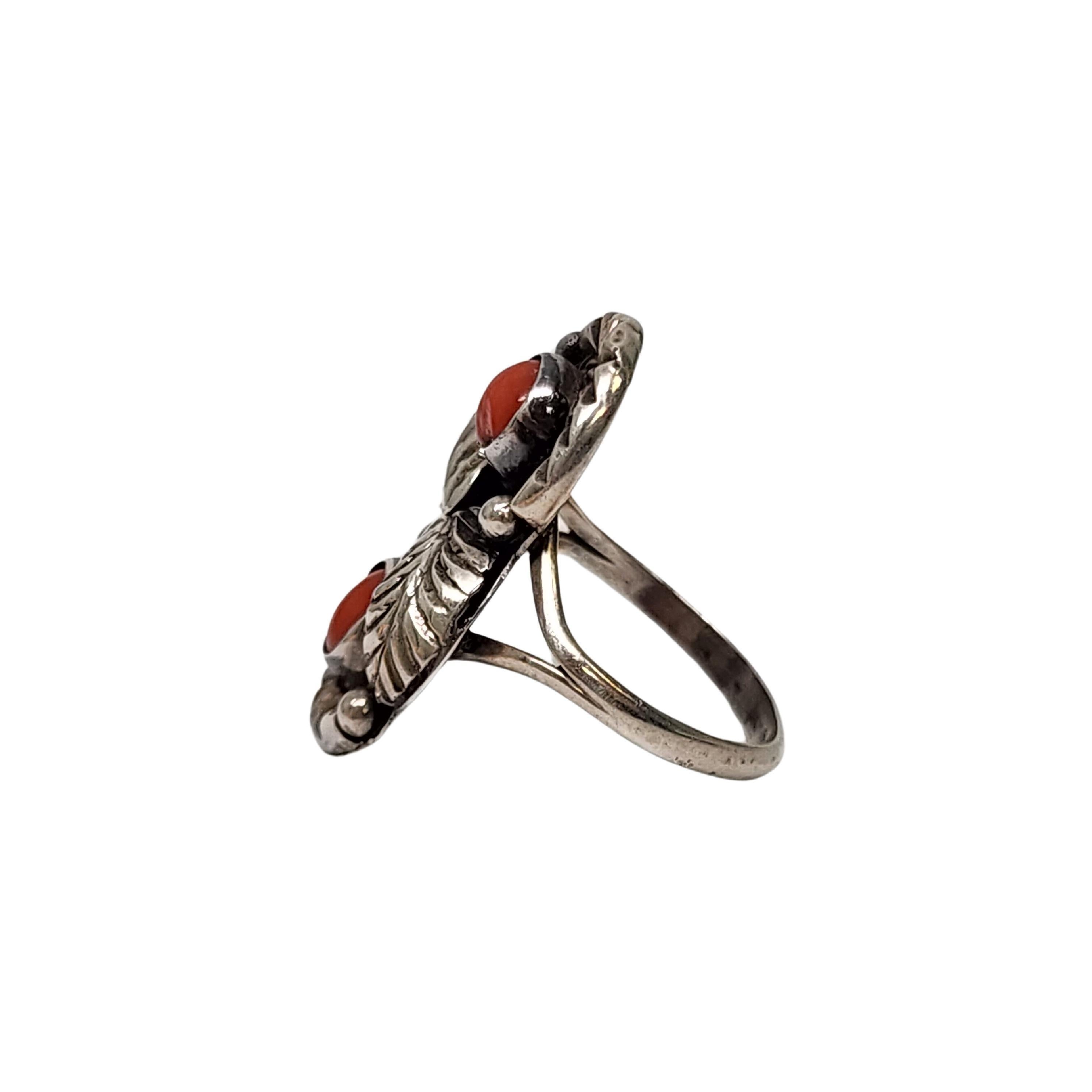 Sterling silver and coral ring by Native American artisan Tom Willetto.

Size 4 1/2

This sterling silver ring features 2 red coral stone bezel set with feather and etched accents.

Weighs approx 4.2g, 2.7dwt

1