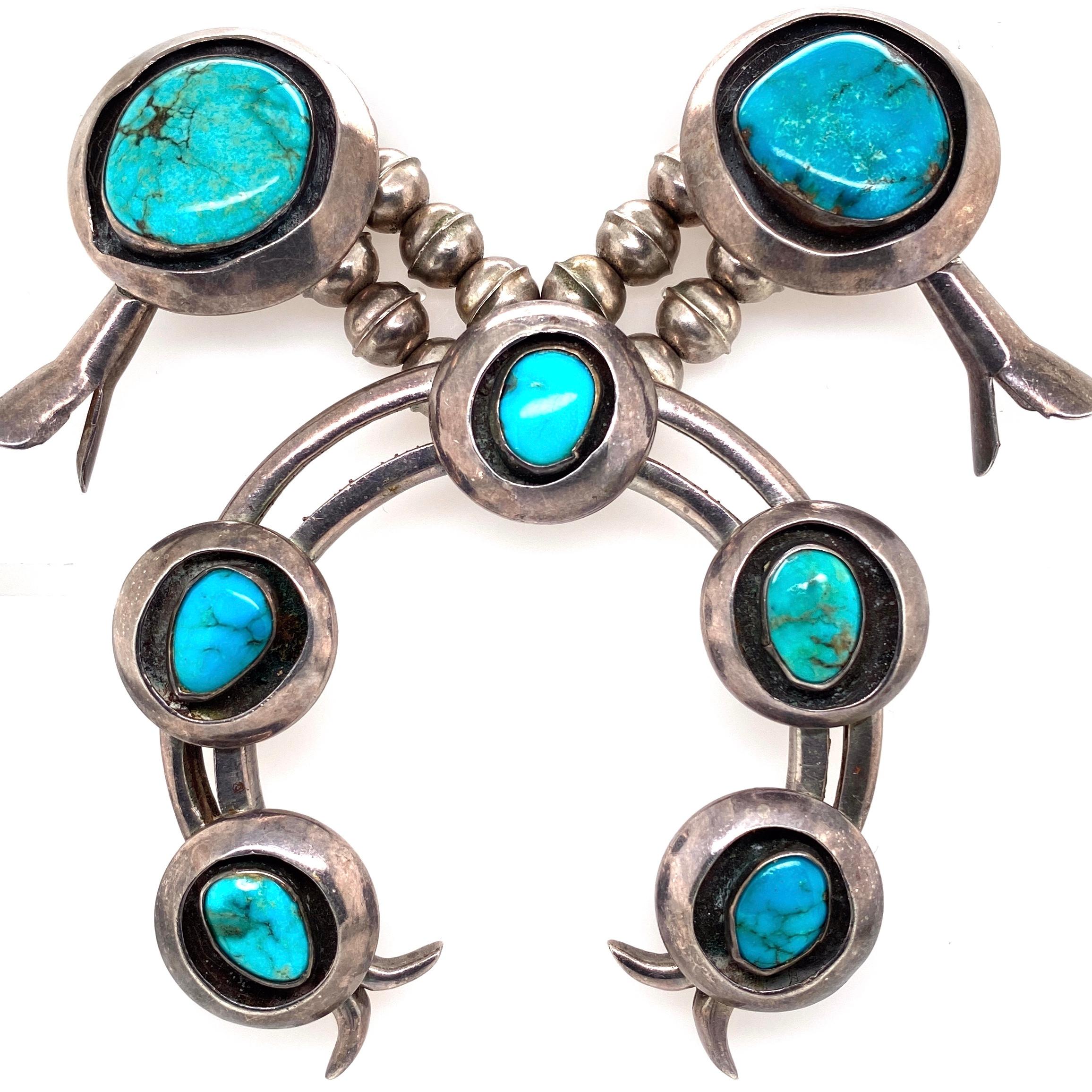 Highly desirable Large Native American original Old Pawn Navajo Squash Blossom Necklace. Featuring 12 Turquoise stations with a large center horseshoe Pendant set with 5 oval Turquoise. Hand crafted 924 Sterling Silver mounting has beautifully
