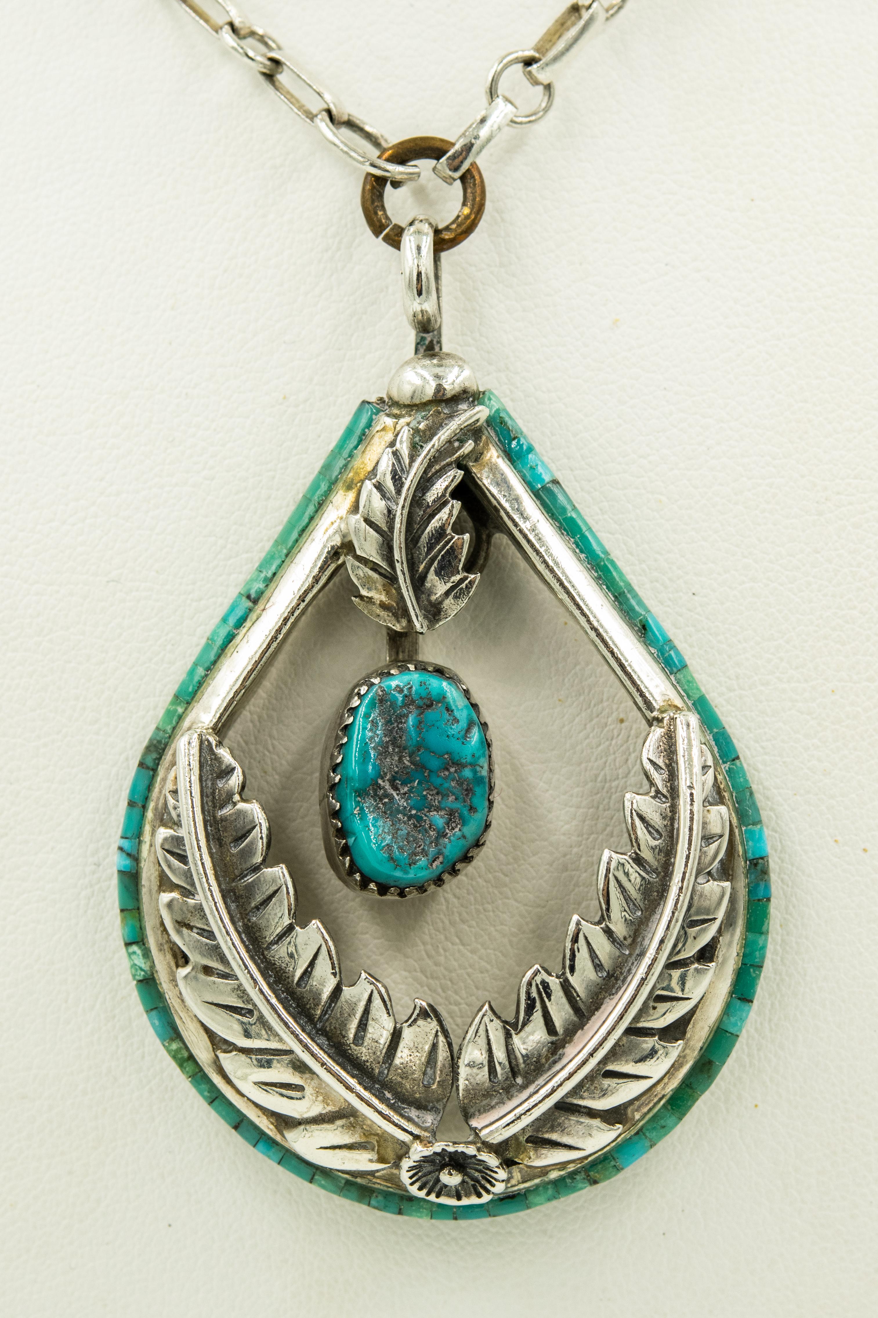 Native American sterling silver collar with two rows of  tightly strung turquoise beads between three rows of twisted ropes.  From the collar, dangles a matching with sterling and turquoise teardrop dangling pendant with a silver flower and leaf