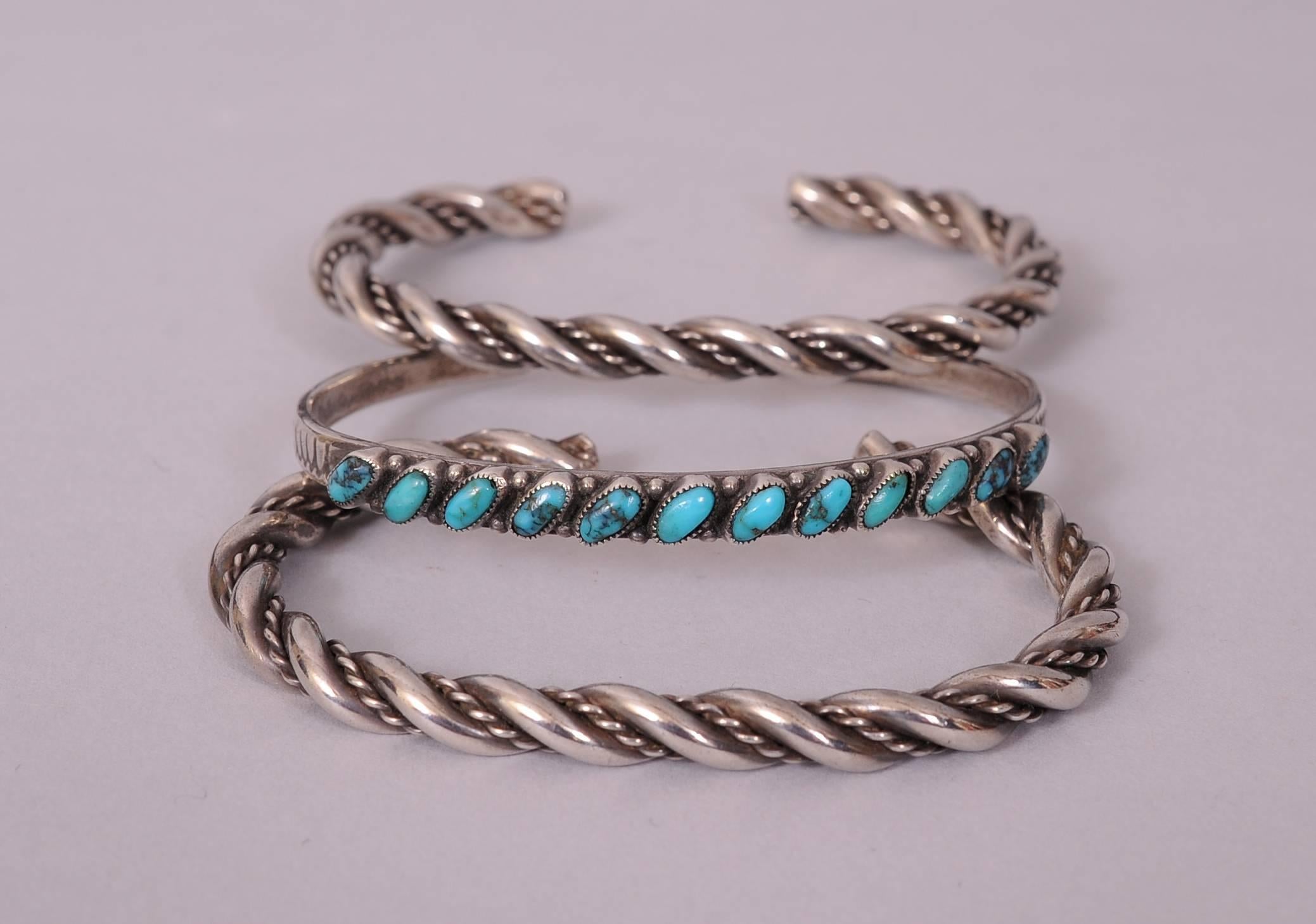 Un paio di braccialetti d'argento dei nativi americani sono abbinati a un braccialetto d'argento e turchese per un'incantevole serie di braccialetti d'argento e turchese. Tutti e tre sono in condizioni eccellenti con una leggera