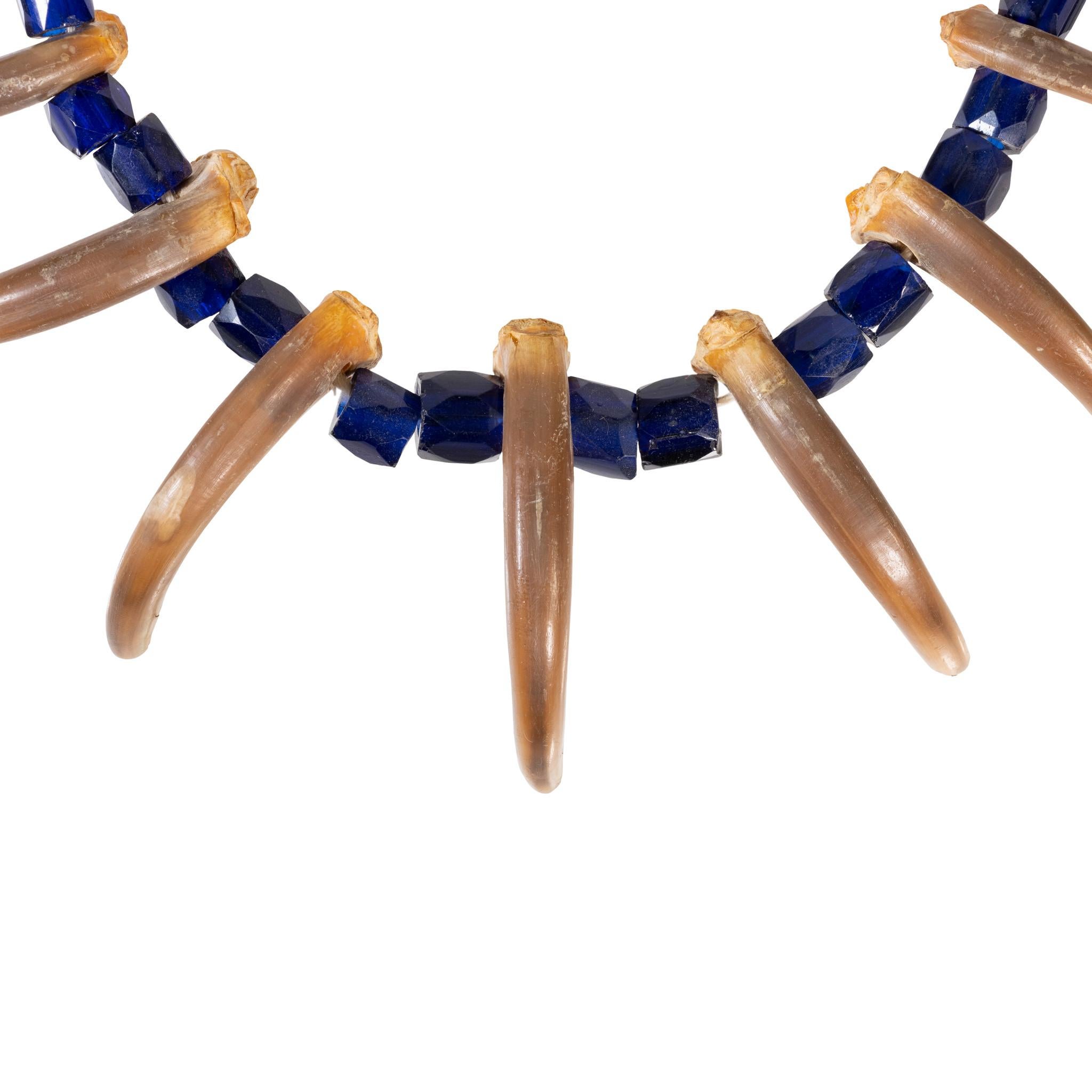 Warrior's grizzly claw necklace. Nine claws interspersed with Russian blue trade beads. Collected from the Spokane Tribe.

PERIOD: Circa 1920 Beads Earlier
ORIGIN: United States
SIZE: 20