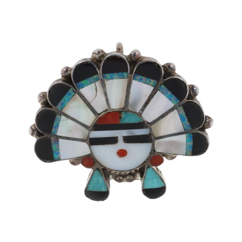 Native American
Tribal Affiliation: Zuni

Metal Content: 925 Sterling Silver

Stone Information

Mother of Pearl
Cut: Inlay
Color: White

Jet
Cut: Inlay
Color: Black

Coral
Cut: Inlay
Color: Orangey Red

Turquoise
Treatment: Routinely Enhanced
Cut:
