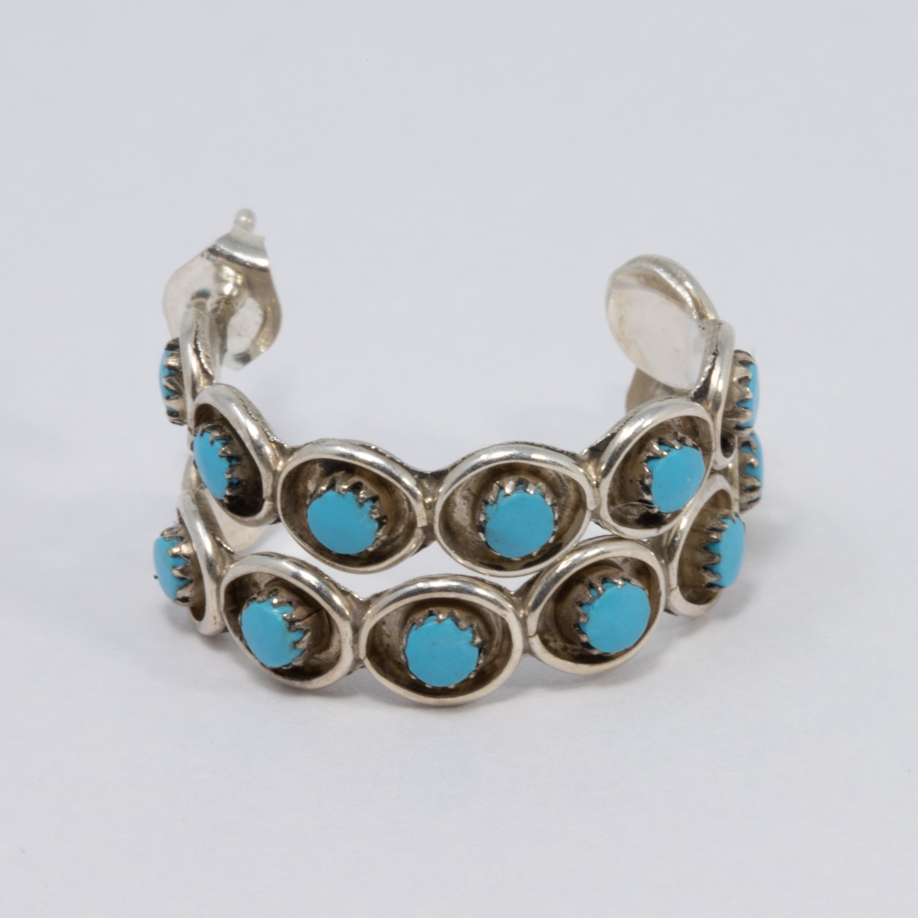 A pair of Native American handcrafted hoop earrings, featuring polished turquoise cabochons bezel set on a round sterling silver setting. Post back hardware.

Diameter - 20 mm