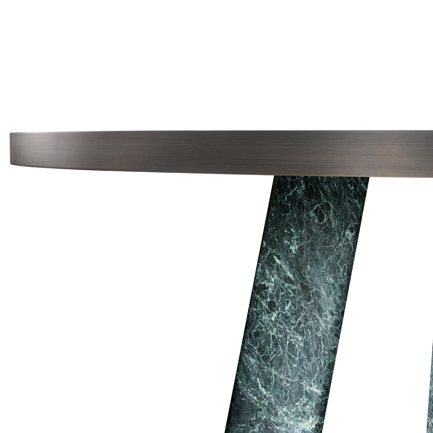 This exquisite dining table is an exercise in bold geometric volumes, their clean aesthetic functional to emphasize the beauty of Verde Alpi marble. The natural stone is seductive in its unpredictable tracery and shades that make each table entirely