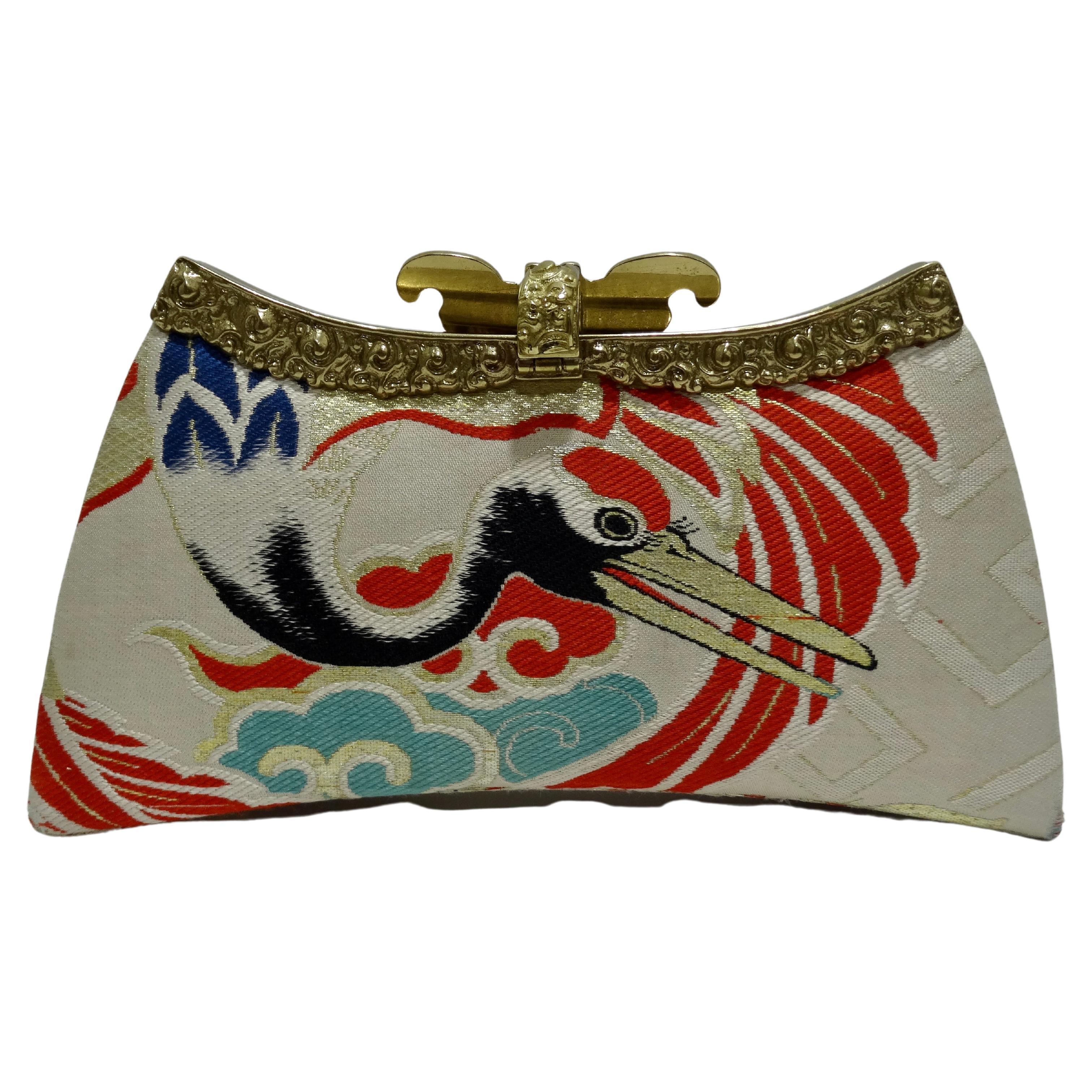 Beautiful Natori metal framed clutch with crane detail made from a vintage OBI fabric. There are hues of electric blue, orange, and gold. The designer did not spare on the details to add a certian decadence to this bag. Details include a beautiful