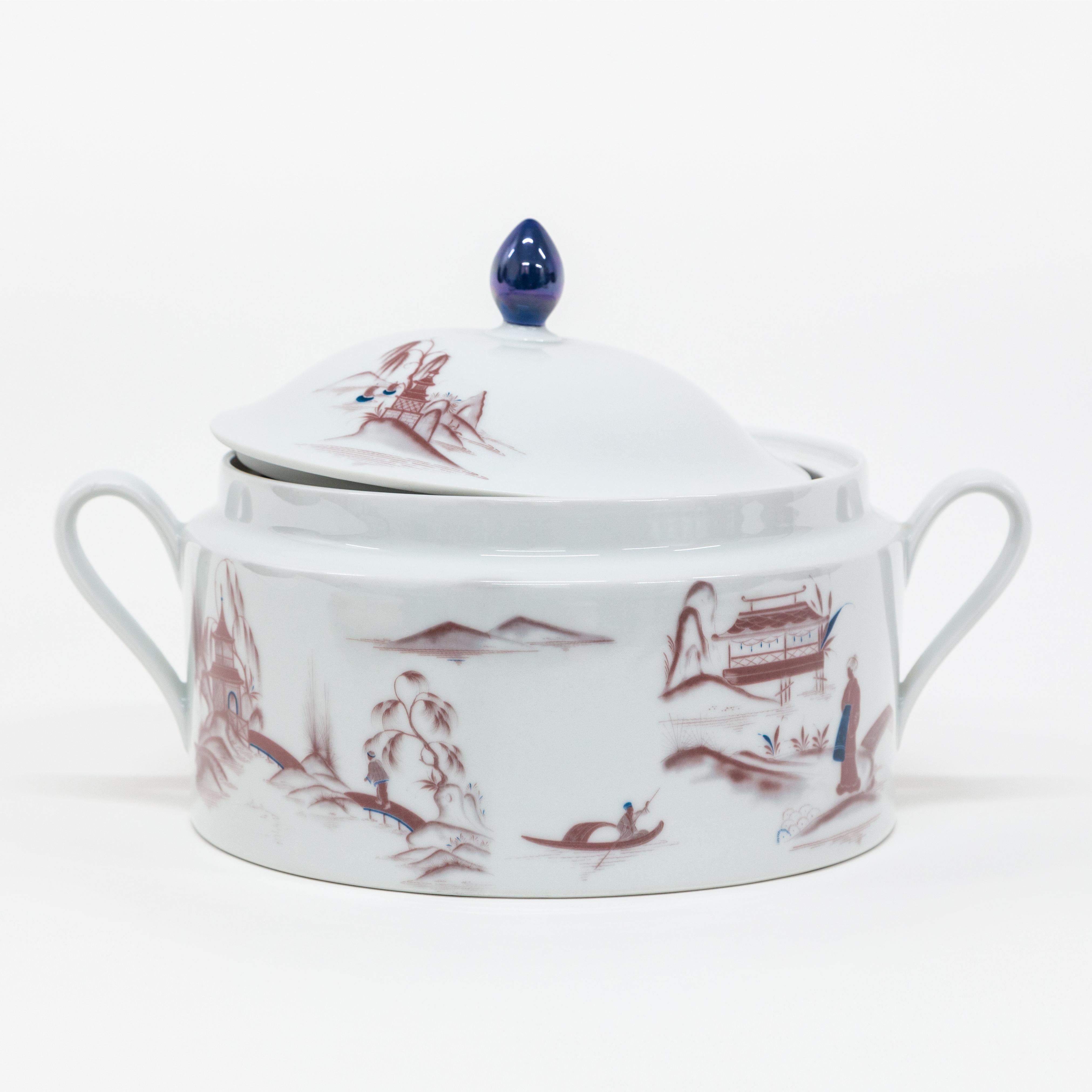 This soup tureen is part of the Grand Tour by Vito Nesta collection Natsumi, inspired by the artist's travels around the world. The Japanese lake landscape shows us figures going about their daily lives, Geisha conversing, men in small rowing boats