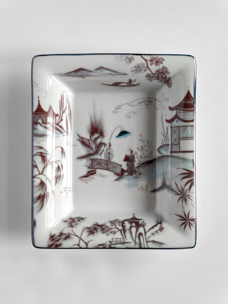 A set of two porcelain pocket emptiers/ashtray with a classic shape and unique printed design. Natsumi vase evoke dream-like images of Japanese landscapes. Rendered in the Imari tradition, the dominant color is reddish-orange, while a striking touch