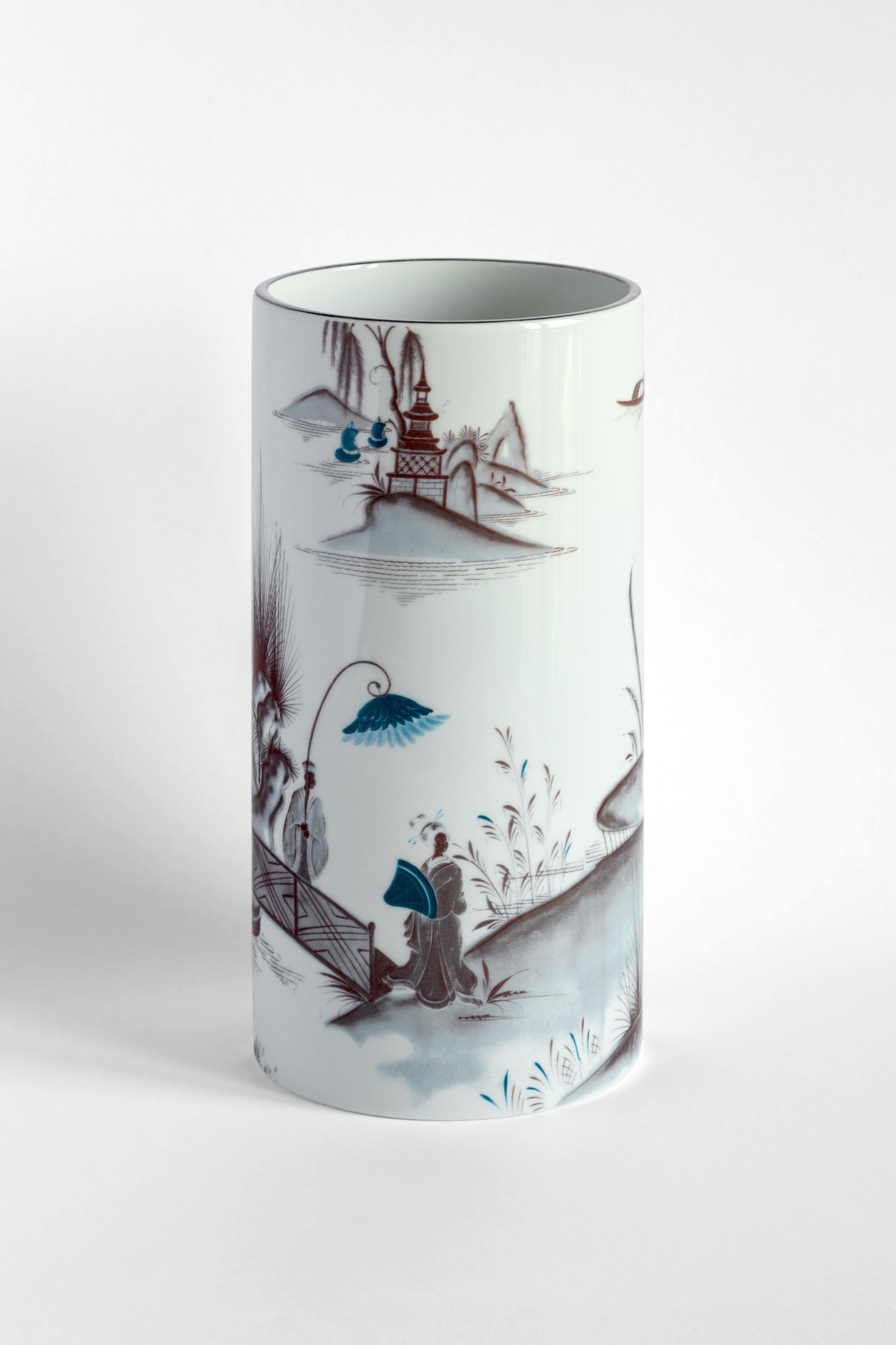 Part of the Grand Tour collection by Vito Nesta, the Natsumi series of porcelain plates is inspired by the artist's travels around the world. The classic Japanese landscape highlights two figures walking on a bridge on a pond surrounded by cherry