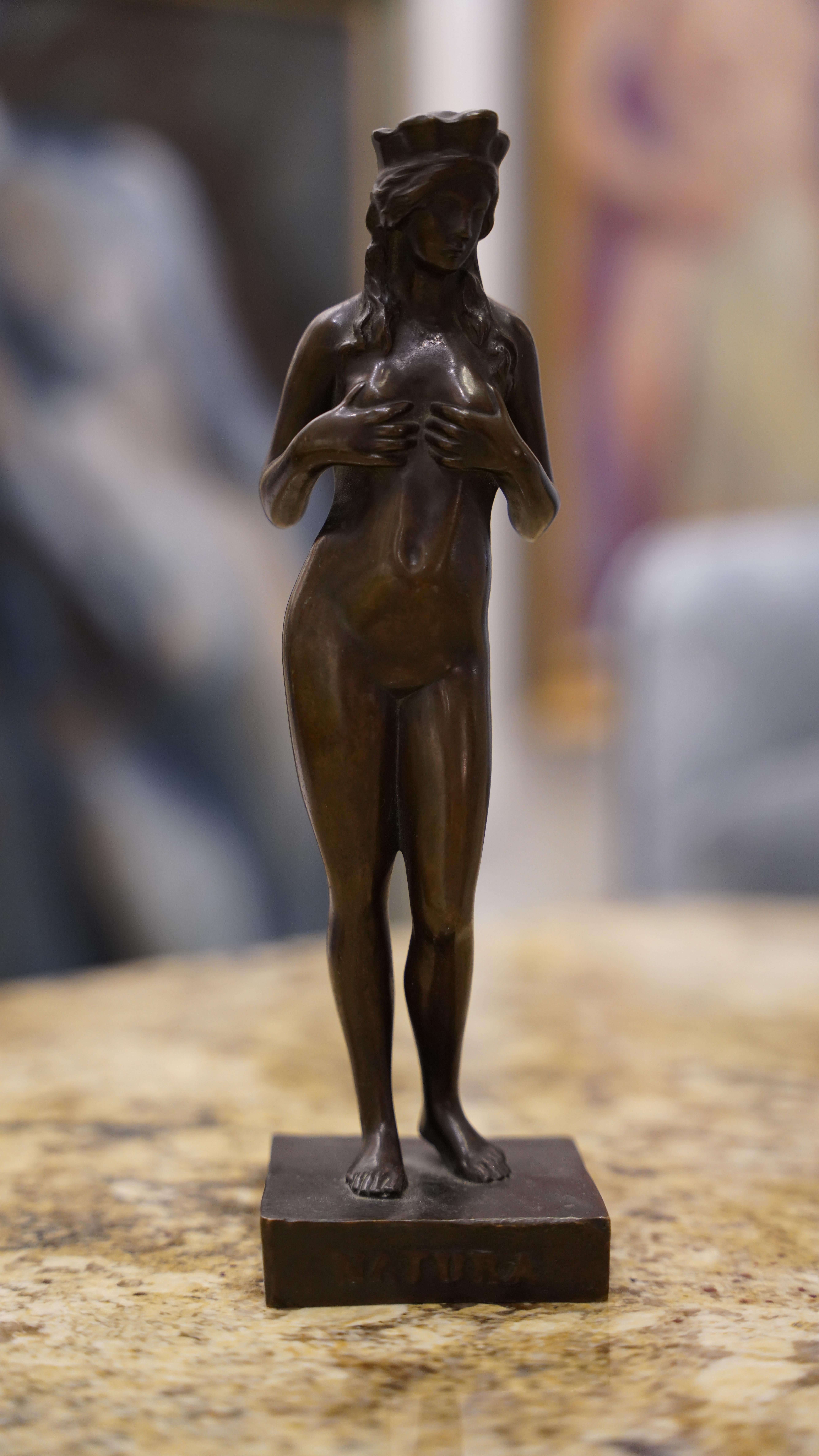 This is a small bronze sculpture of a nude female figure titled 