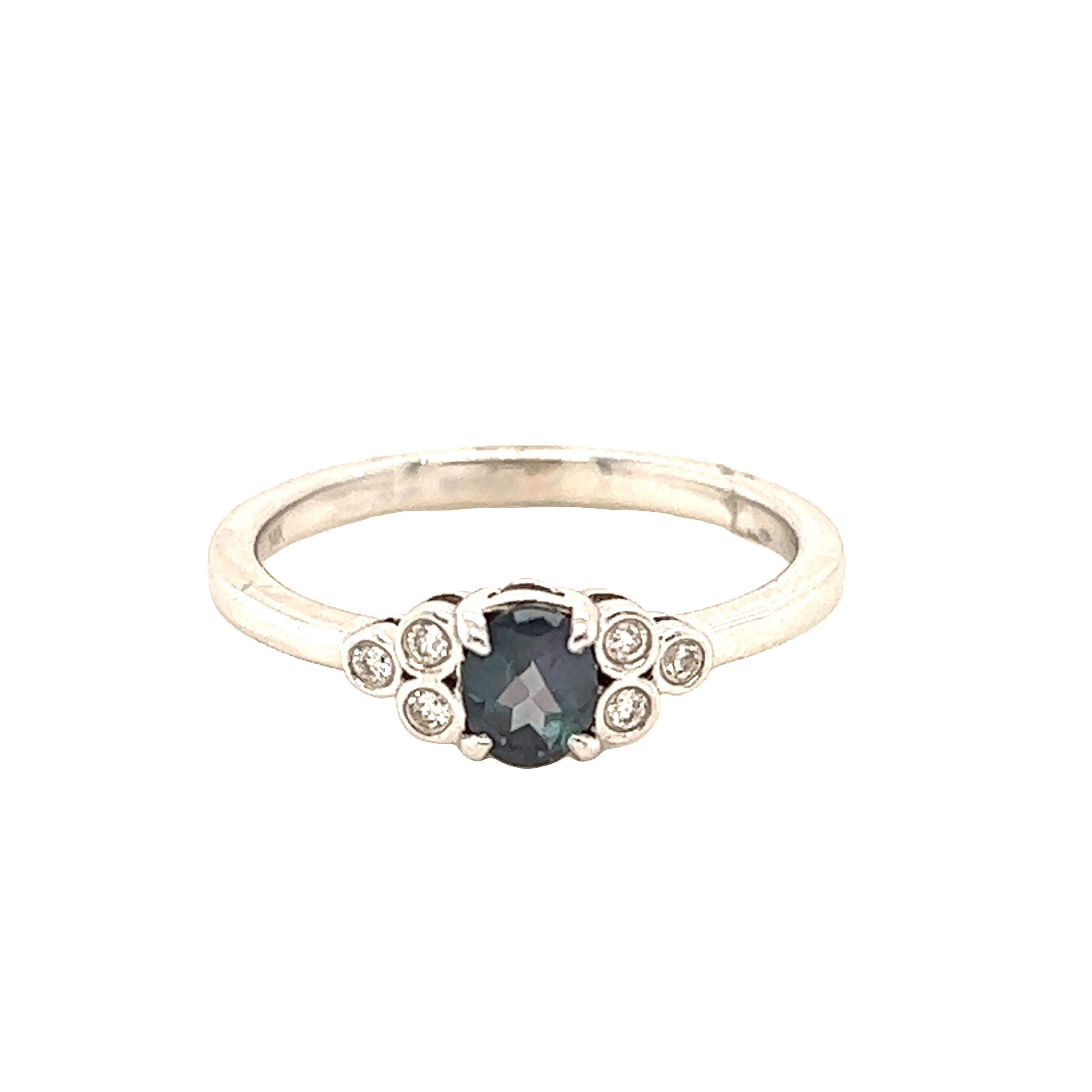 This is a gorgeous natural AAA quality oval Alexandrite surrounded by dainty diamonds that is set in a vintage platinum setting. This ring features a natural 0.39 carat oval alexandrite that is surrounded by brilliant white diamonds. The ring is a