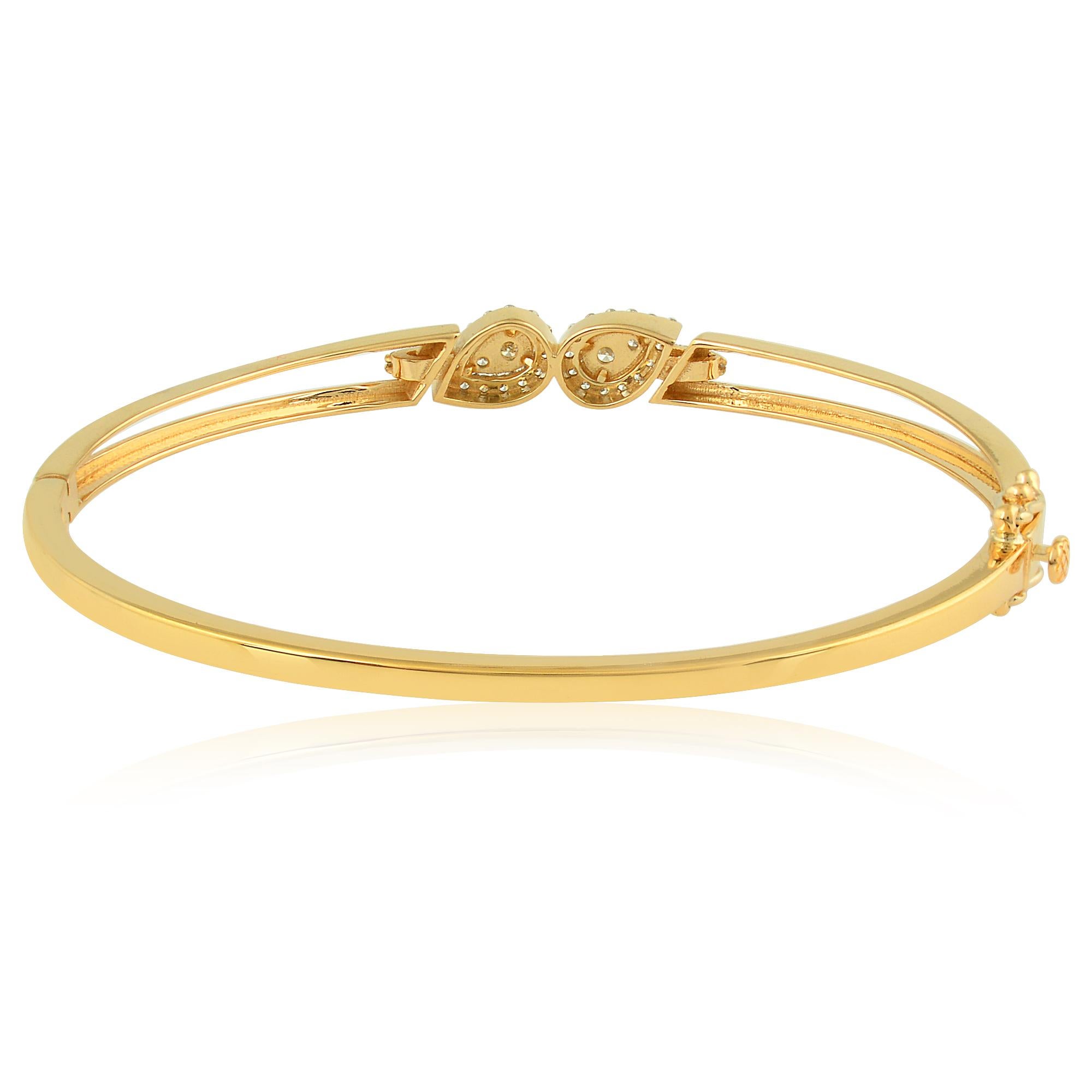 The warm glow of the yellow gold provides the perfect backdrop for the shimmering diamonds, enhancing their natural beauty and adding a touch of timeless elegance to the design. The smooth and polished surface of the bangle ensures a comfortable