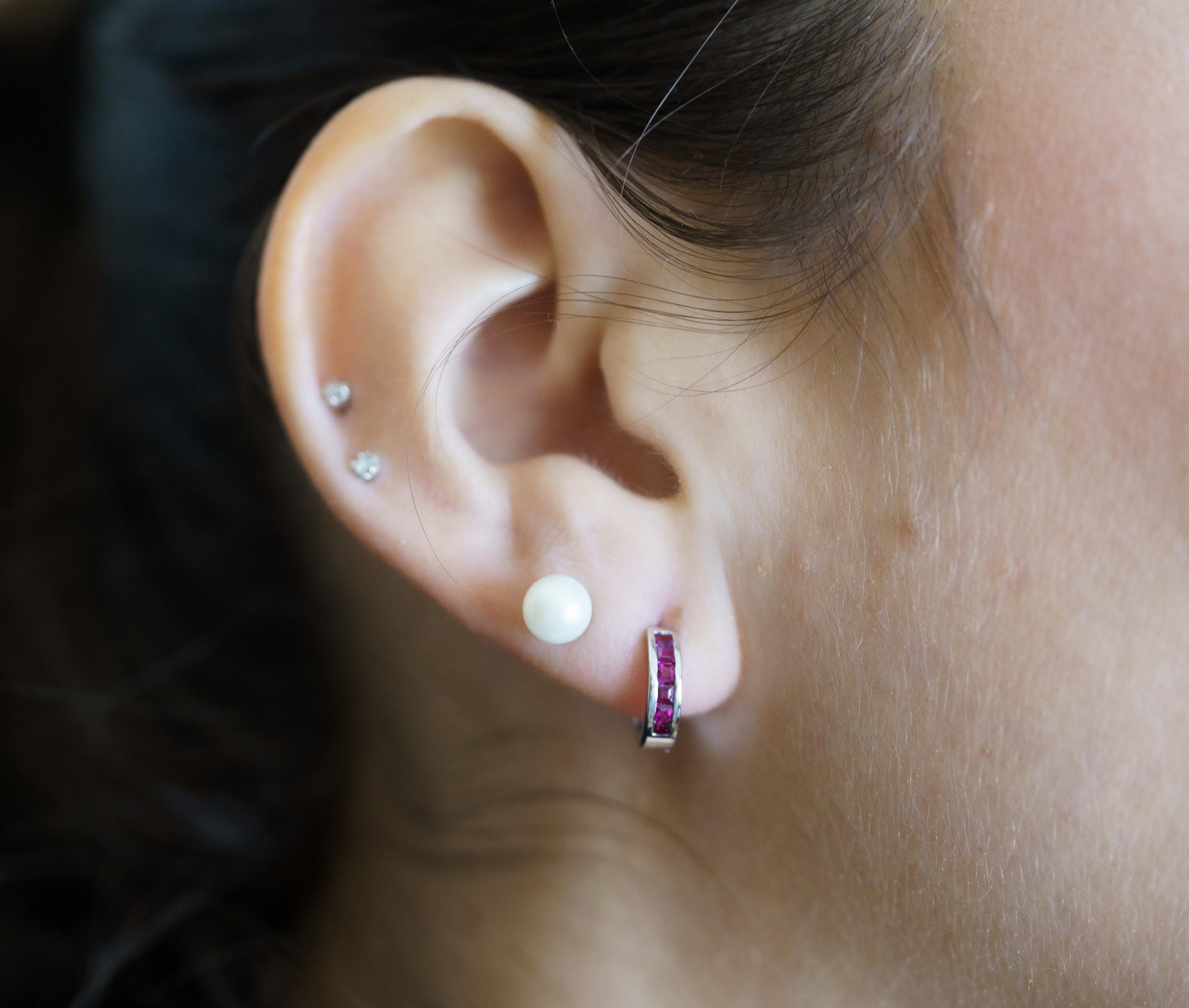 Natural Ruby Huggie Hoop Earrings in 14K White Gold. 

This dazzling pair of earrings, featuring a combined carat weight of 0.44 natural square cut red rubies. The rubies are secured in the channel setting. The perfect pair of natural gemstone