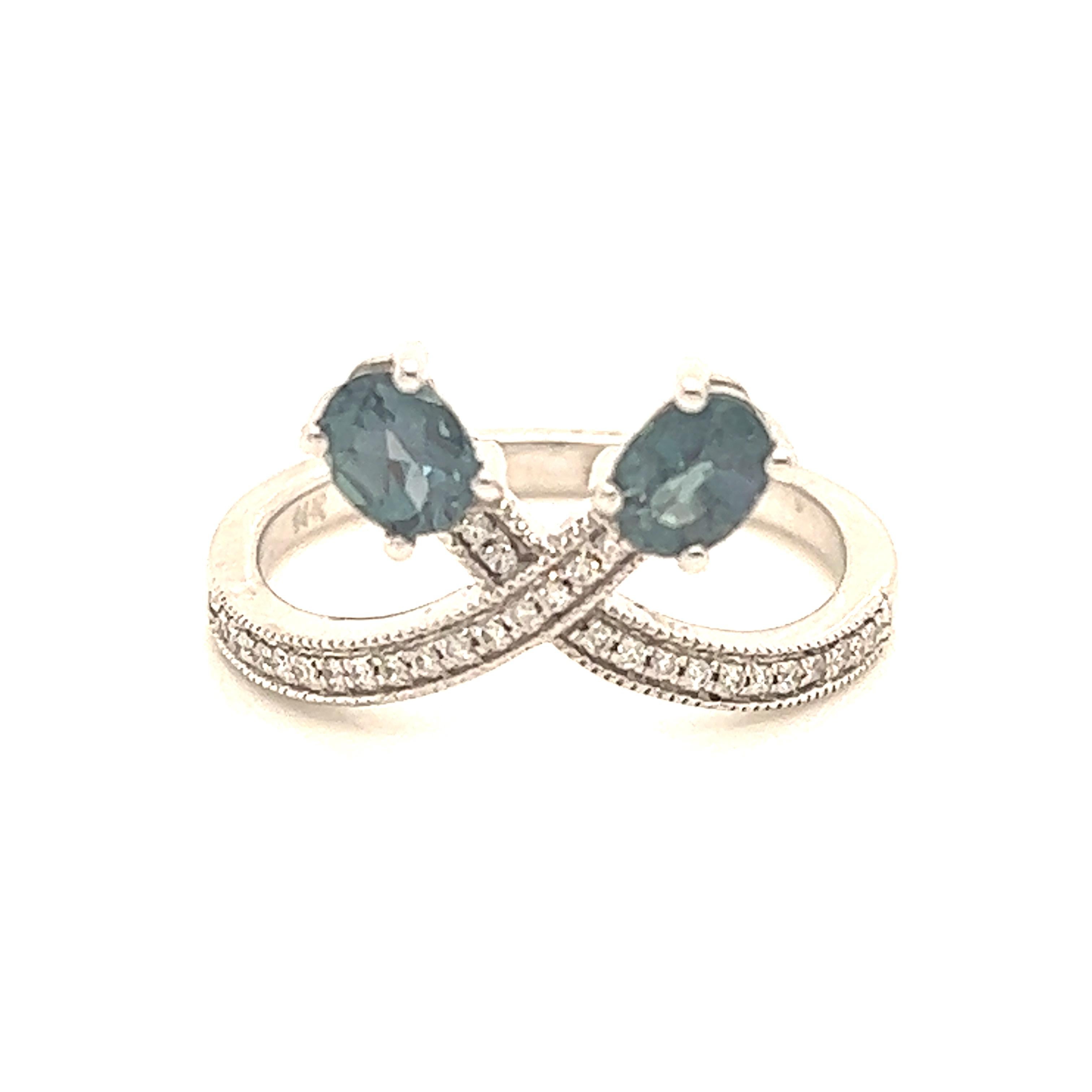 This is a gorgeous natural AAA quality Alexandrite surrounded by dainty diamonds that is set in a vintage White Gold setting. This ring features a natural 0.68 carat oval alexandrite that is surrounded by brilliant white diamonds. The ring is a true