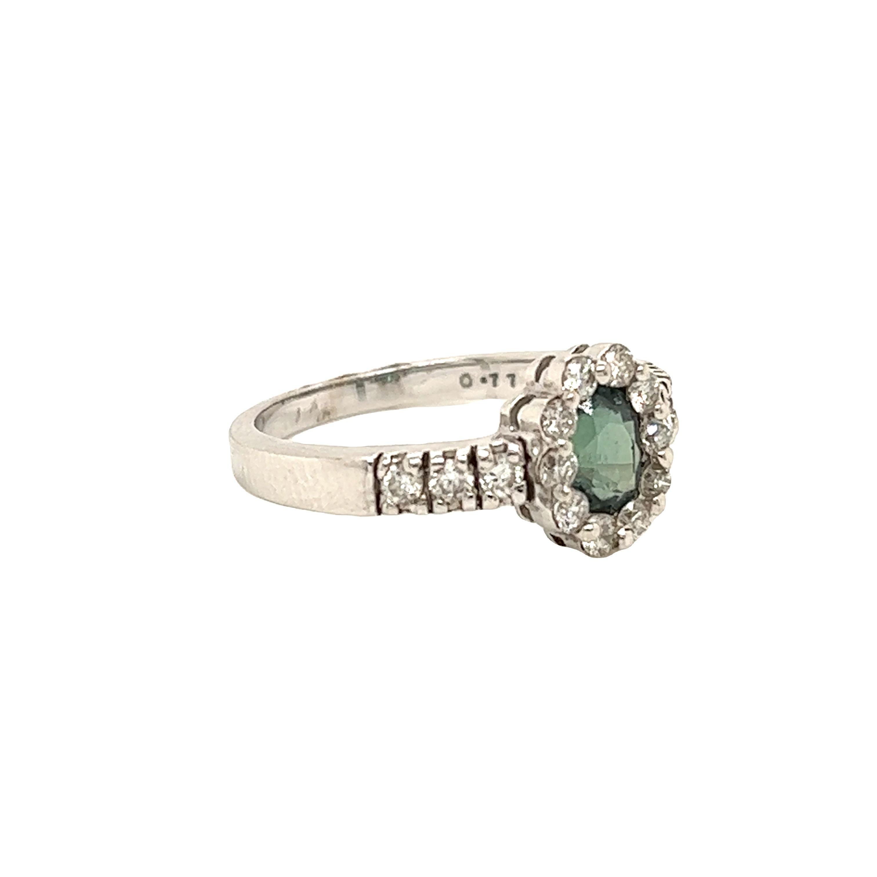 This is a gorgeous natural AAA quality oval Alexandrite surrounded by dainty diamonds that is set in a vintage White Gold setting. This ring features a natural 0.77 carat oval alexandrite that is surrounded by brilliant white diamonds. The ring is a
