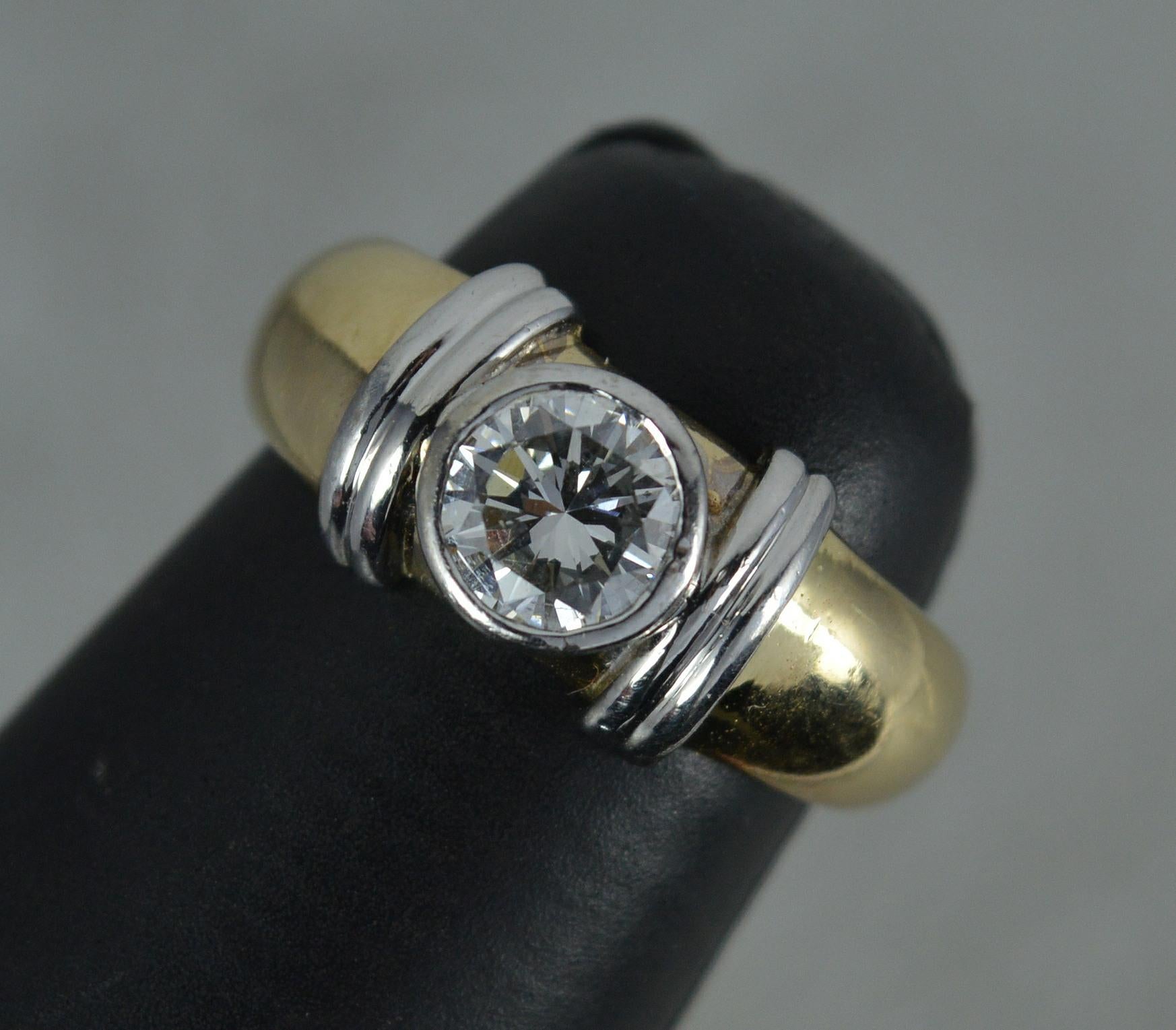 A fine 18 carat gold and diamond ring.
18 carat yelow gold shank with white gold bezel and column shoulder.
The diamond is 5.7mm in diameter and weighs 0.7 carats. Natural, round brilliant cut. Very bright and sparkly, well cut stone.
Protruding