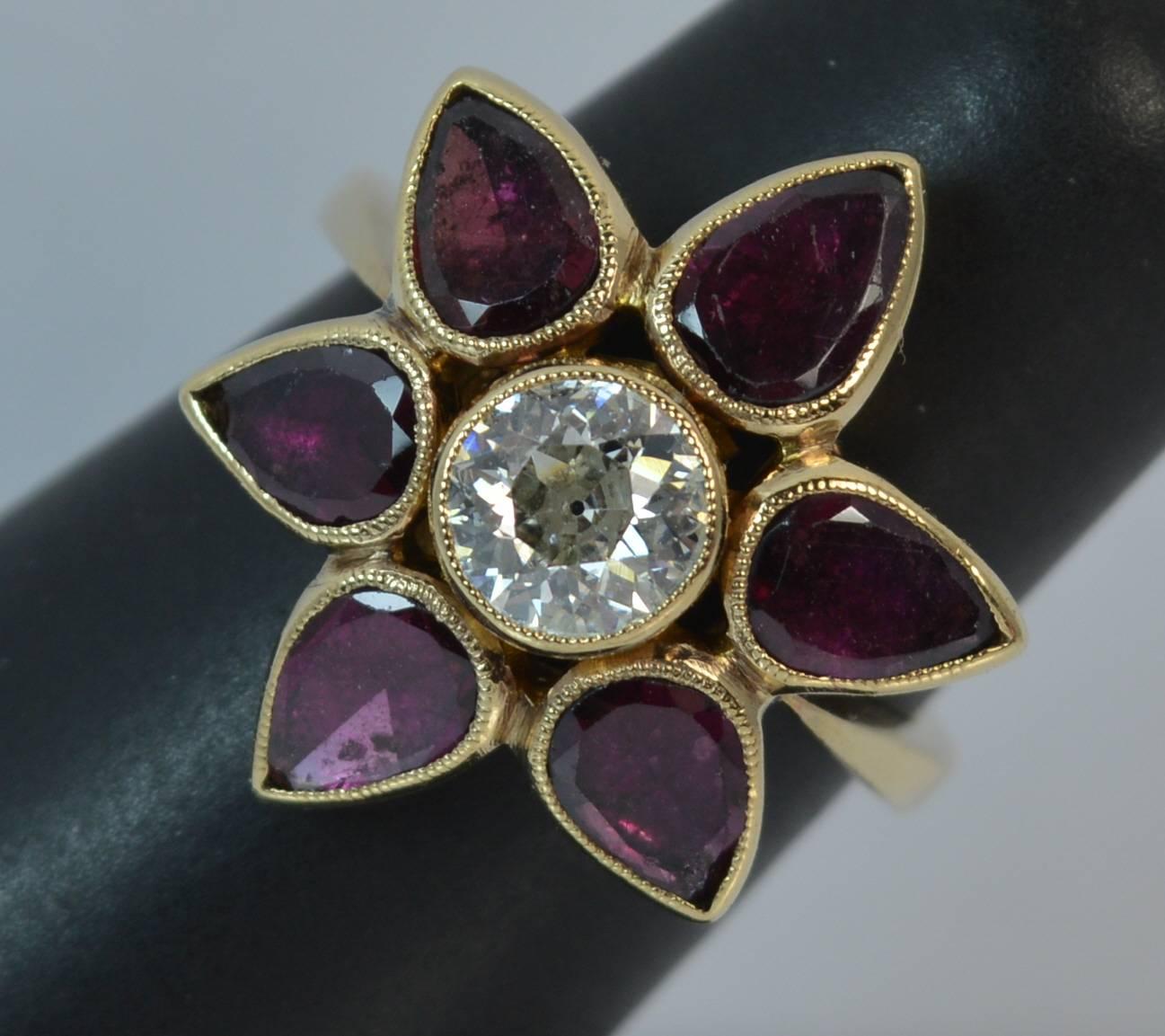 A stunning Old Cut Diamond and Garnet cluster ring.

​Designed with a natural 5.9mm diameter old cut diamond of approx 0.80 carats in collet mount. Surrounding are six natural pear shaped flat cut garnets in a sun burst design.

​The head measures