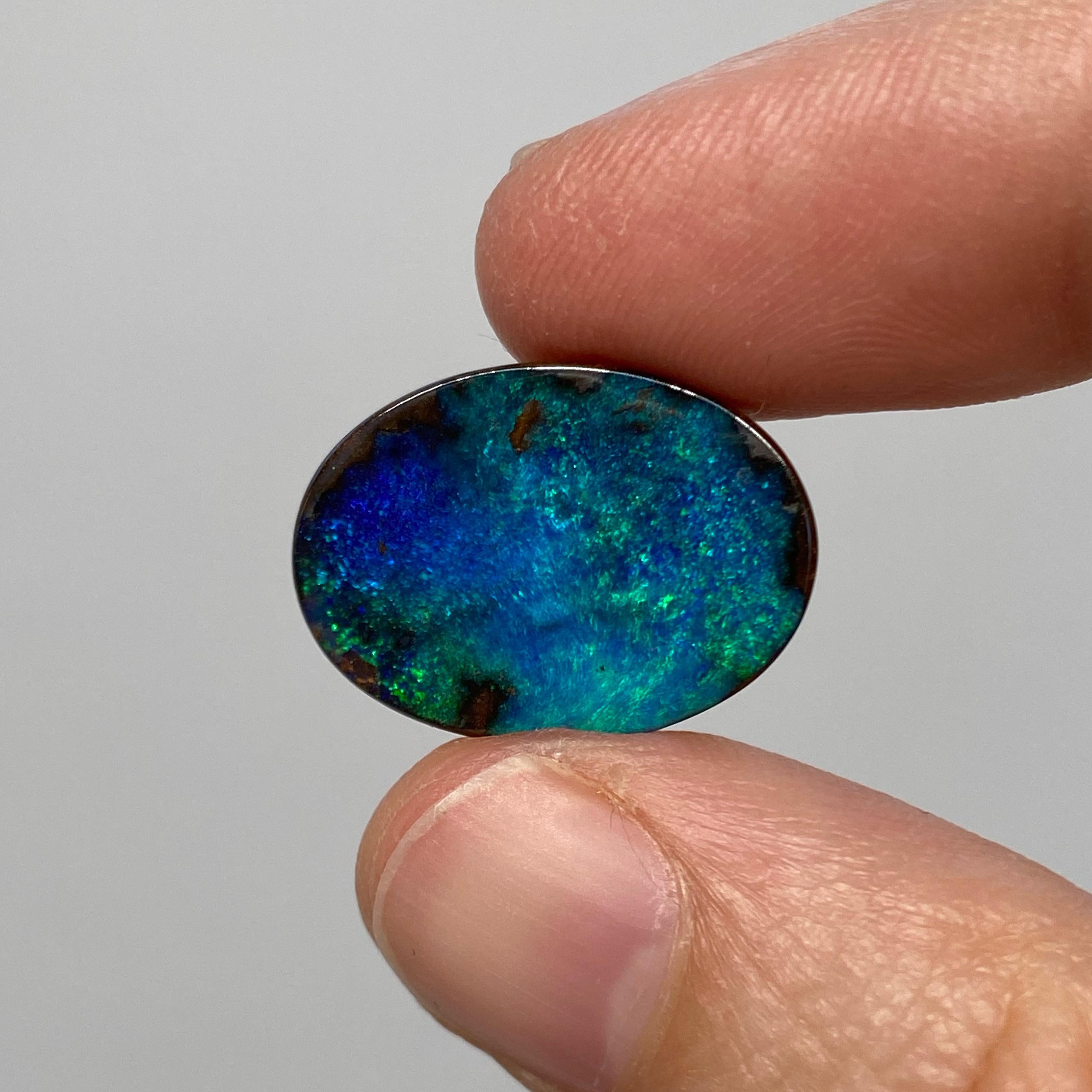 A lovely oval Australian boulder opal with darker green and blue colors. This natural solid Australian boulder opal was mined in western Queensland, Australia by a female opal miner. It has gorgeous green and blue colors and a pinfire-like pattern.