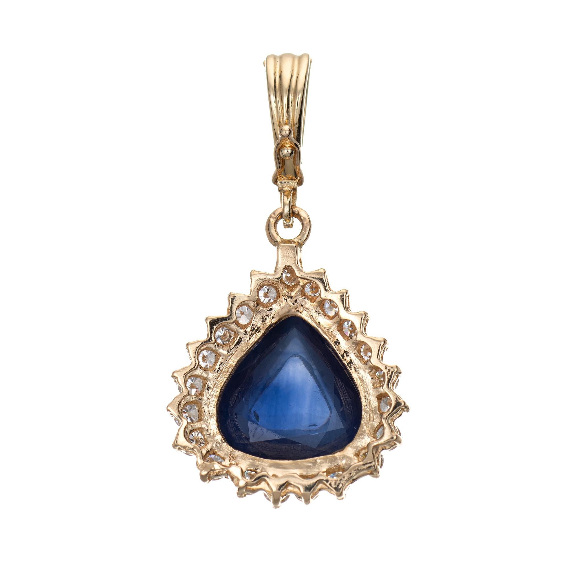 Finely detailed vintage natural Ceylon sapphire & diamond pendant crafted in 14 karat yellow gold. 

One pear shaped cabochon cut natural sapphire, approx. 11.20 carats (13.50 x 12.84 x 5.98mm), dark blue color, lightly included, good cut. Color and