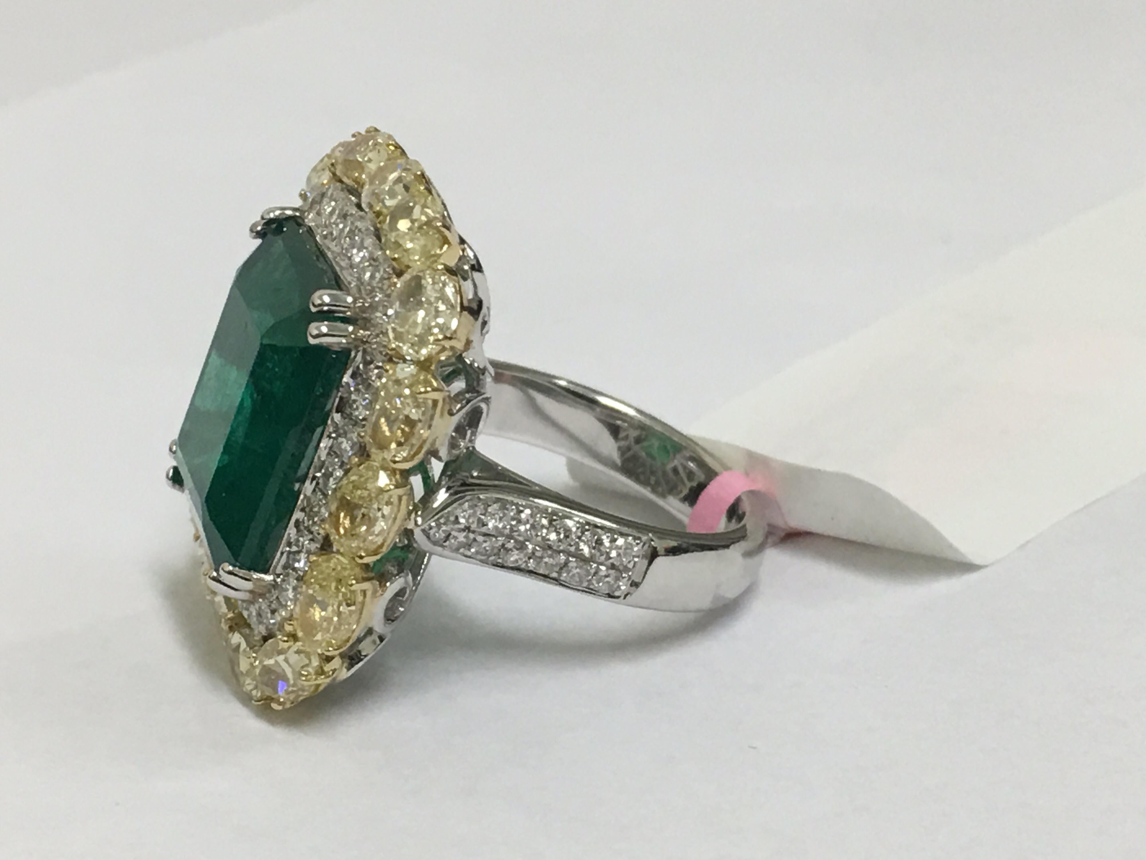 Natural 11.93 Carat Emerald set in 18 Karat Two Tone Gold . The Rectangular Emerald set in halo with 1.11 Carat round white and 5.23 Carat Oval all matched yellow is one of a kind handcrafted Ring. Workmen ship and quality of diamonds and emerald 