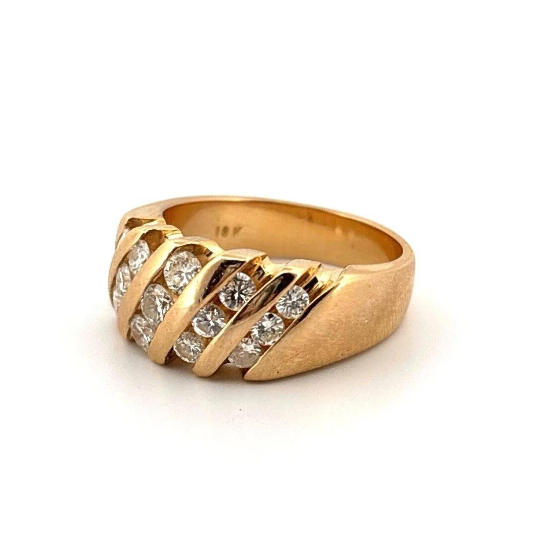 Striking and substantial, this bold estate ring is crafted in solid 18K yellow gold, featuring a stepped five-row design with fifteen (15) round brilliant cut diamonds, each channel-set in diagonal rows. The diamonds weigh approximately 1.20 carats