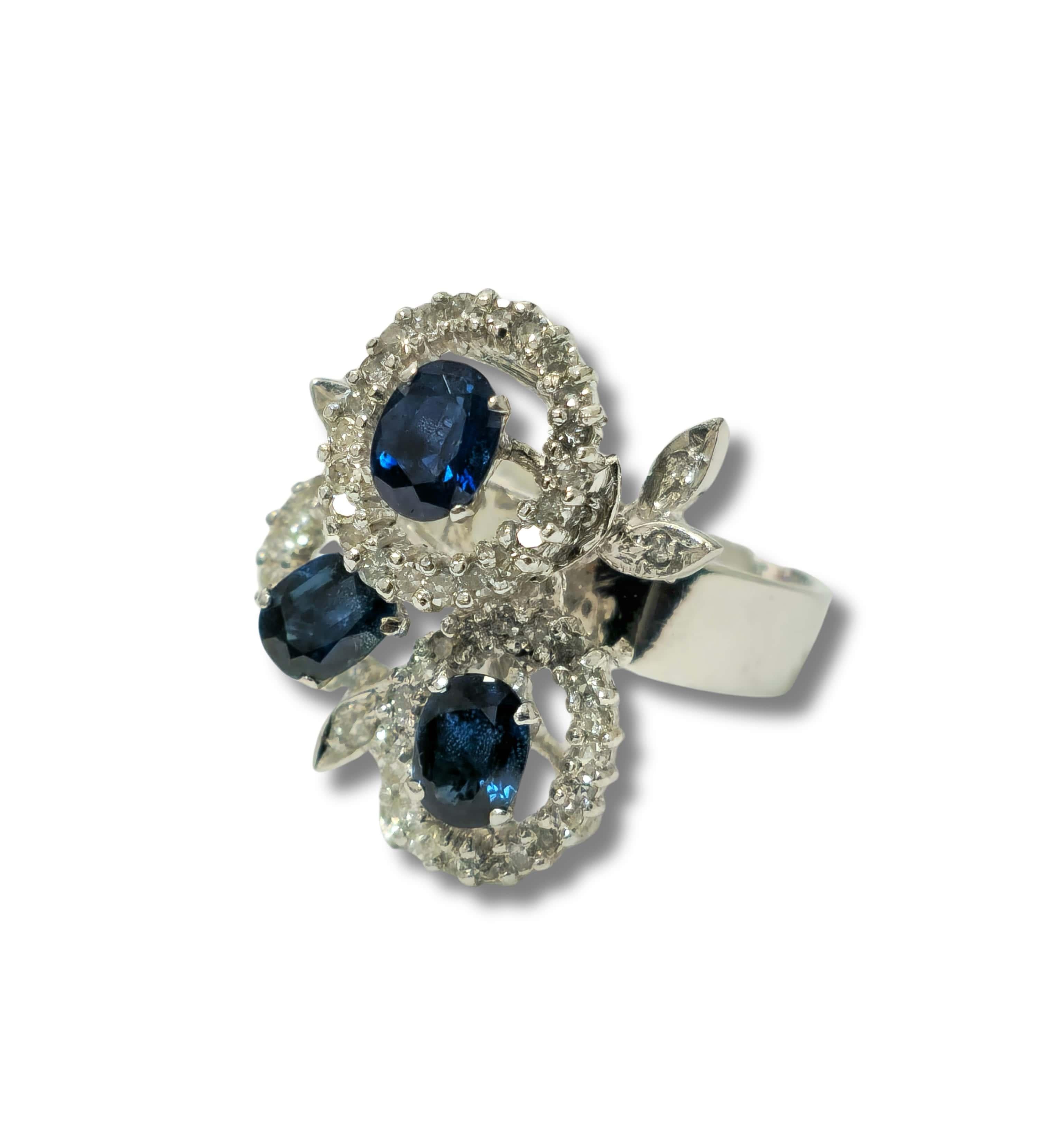 Embrace timeless elegance with our Majestic Vintage Sapphire and Diamond Ring, meticulously crafted from luxurious white gold. Adorned with stunning round brilliant cut diamonds and oval-cut cornflower blue sapphires, each boasting VS-SI clarity and