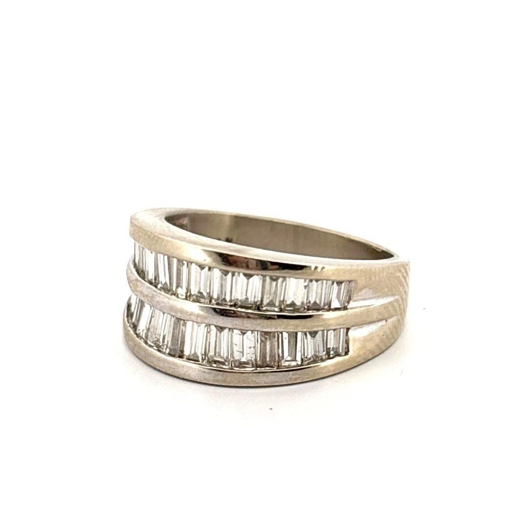 Offered is a bold and elegant baguette diamond band ring crafted in solid 14K white gold, showcasing two rows of straight baguette-cut diamonds, concave-set in polished channel grooves. The diamonds are set halfway around the band, creating a modern