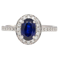 Bague en or blanc 18 carats avec saphir bleu de taille ovale de 1,45 carat et halo de diamants