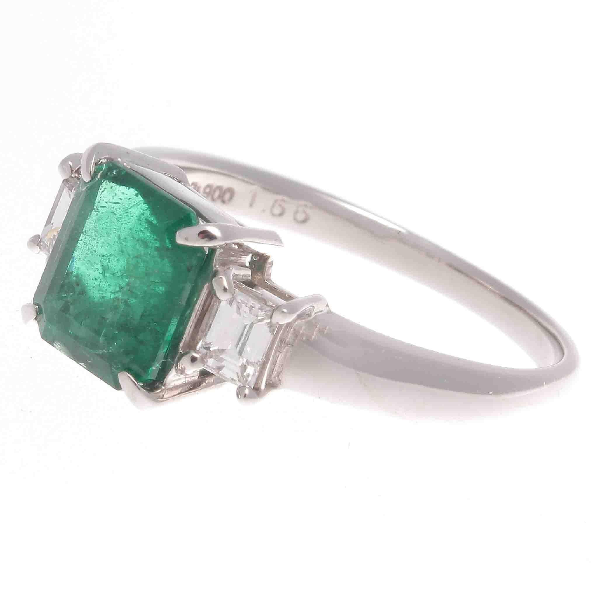A classic creation of style and grace that has survived many decades of change. Featuring a vibrant 1.66 carat transparent green emerald that is perfectly complimented by 2 emerald cut diamonds weighing a total of 0.29 carats. Crafted in