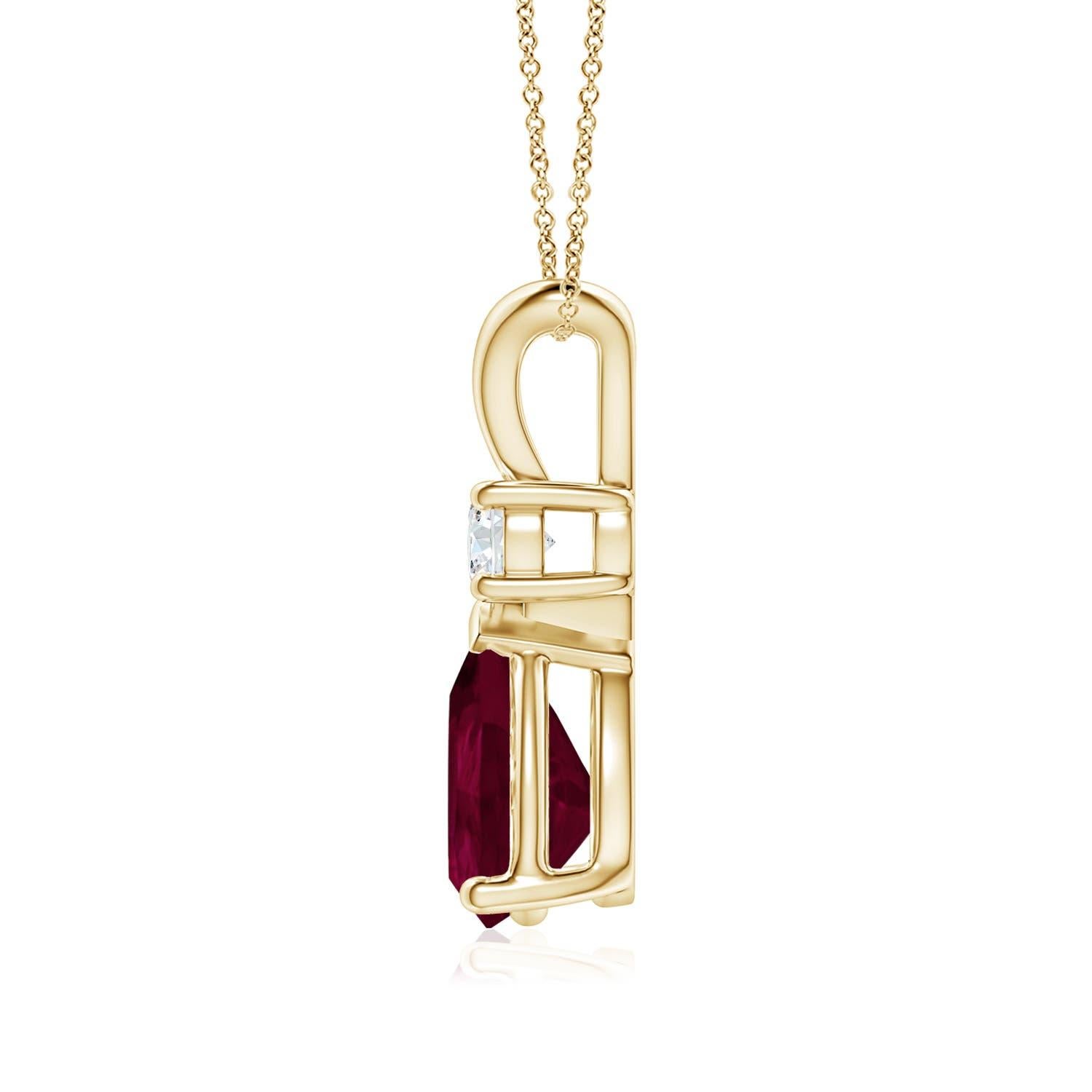 Ce pendentif solitaire classique est orné d'un rubis en forme de poire serti dans une monture à griffes. Un diamant rond brillant surmonte la pierre précieuse de couleur rouge pourpre. Simple mais séduisant, ce pendentif en or jaune 18k orné d'un