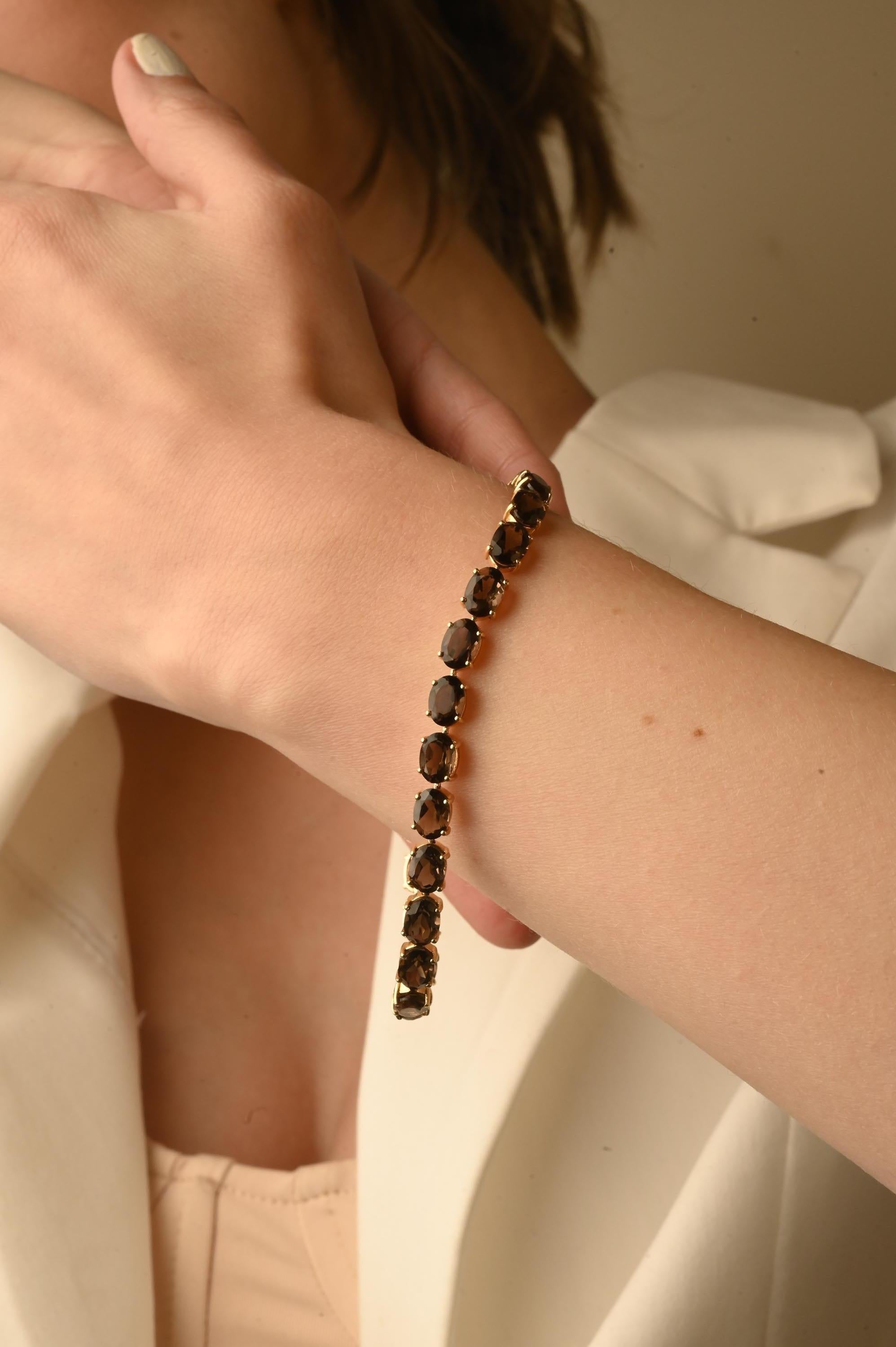 This Brown Quartz Tennis Bracelet in 14K gold showcases 25 endlessly sparkling natural smoky quartz, weighing 18.47 carat. It measures 8 inches long in length. 
Smoky quartz relieves stress and promotes positive thought. 
Designed with perfect oval