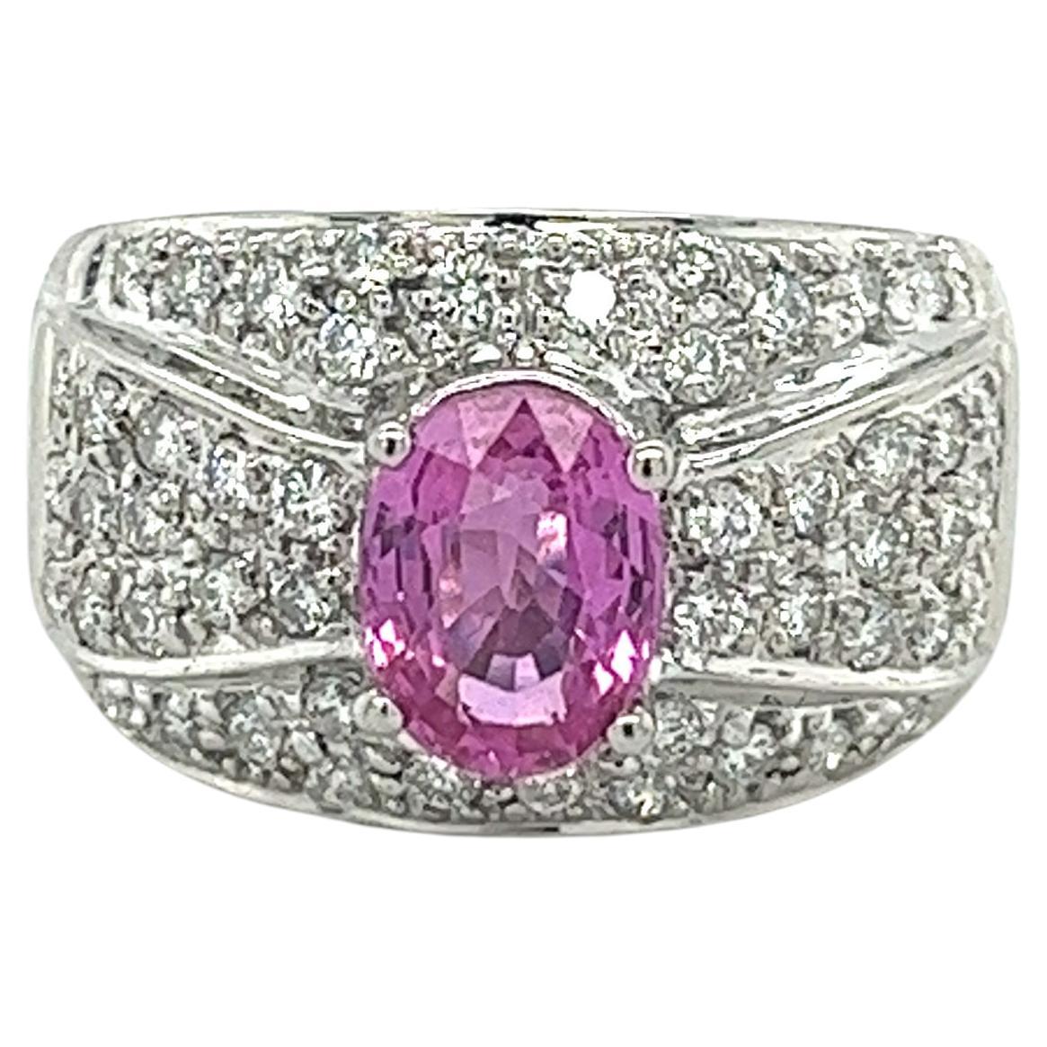 Intricately paired together, this pink sapphire and diamond ring boasts an exceptionally colored oval cut 2 carat Pink Sapphire center stone. Surrounded by a cluster of round cut white diamonds, the ring itself is made from 18k white gold. Dome