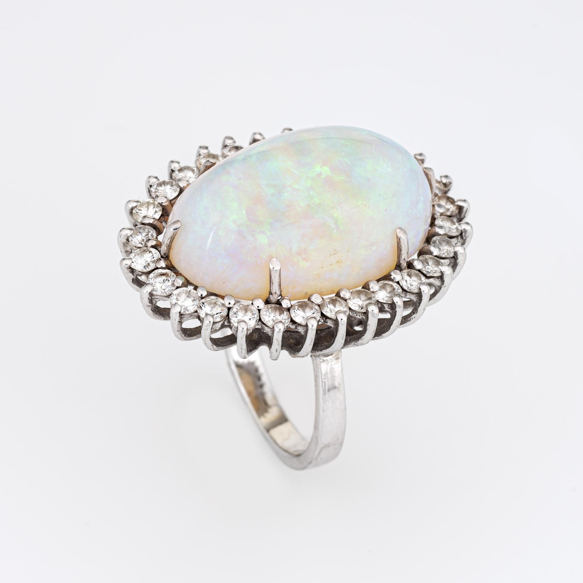 Stylish vintage natural opal ring (circa 1970s to 1980s) crafted in 14 karat white gold. 

Natural opal measures 22mm x 14.5mm (estimated at 22 carats). The opal is in very good condition and free of cracks or chips. Round brilliant cut diamonds