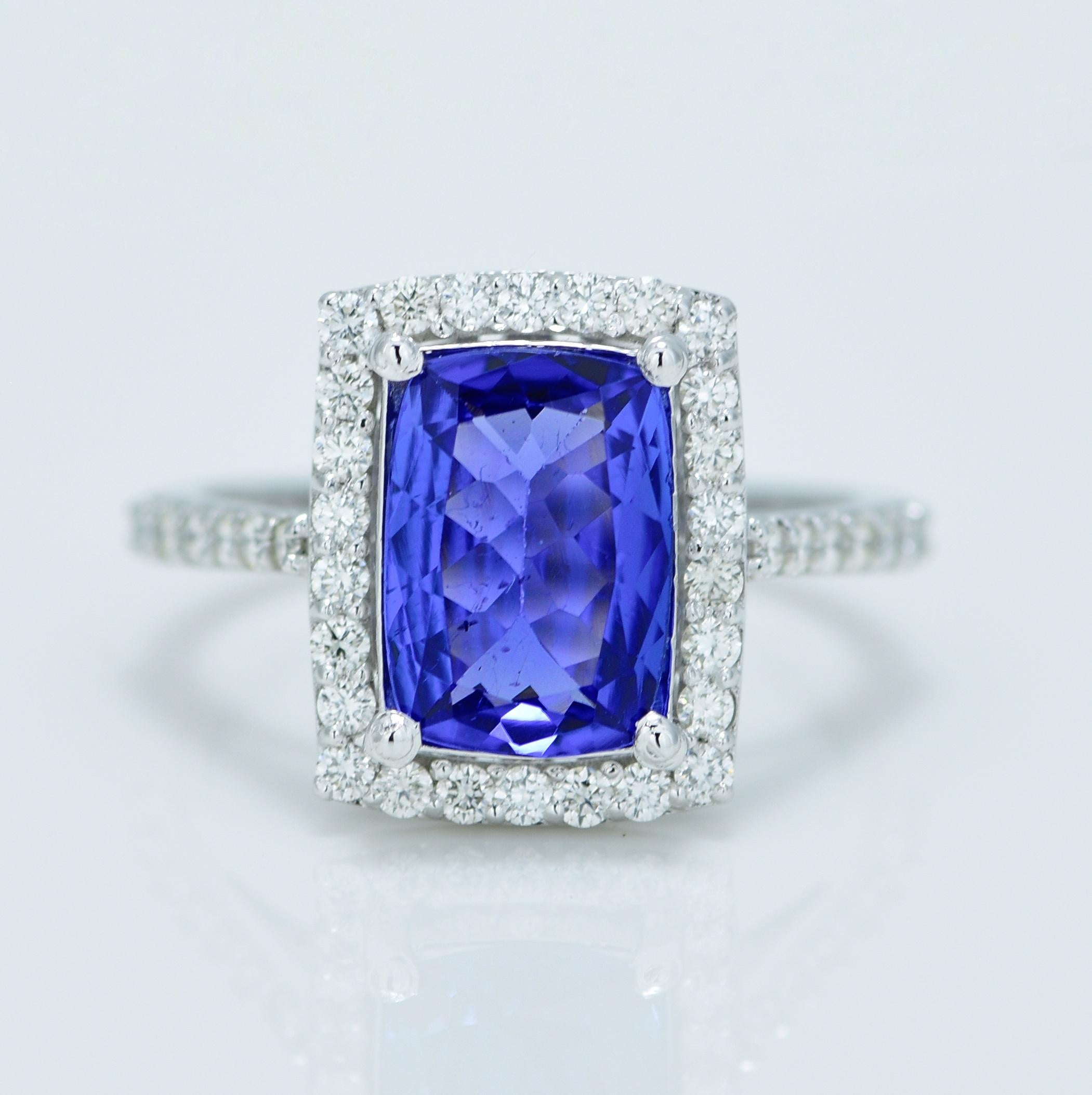 Stunning Violetish Blue Tanzanite and Diamond halo ring.

Centre Stone - Natural Tanzanite, 
Centre Stone Weight - 2.32 Carat, 
Centre Stone Shape & Cut - Long Cushion Step Cut
 
Total Number of Diamonds - 40, 
Diamonds Carat Weight - 0.57