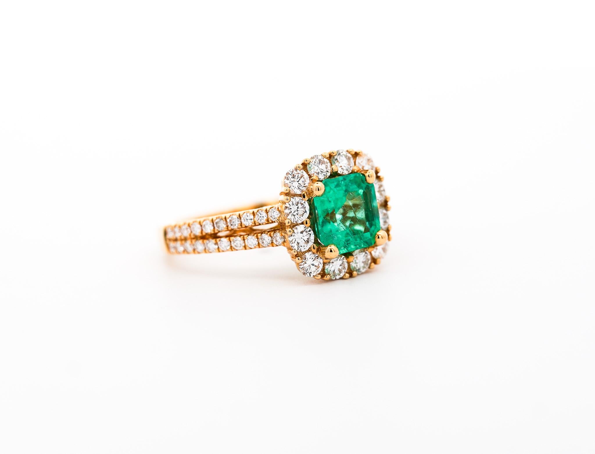 18k solid yellow gold ring, featuring a 1.49 carat natural Colombian emerald and a round cut diamond halo and double row ring shank. Set with an open back to allow the emerald natural color to be on full display. The emerald center stone bears