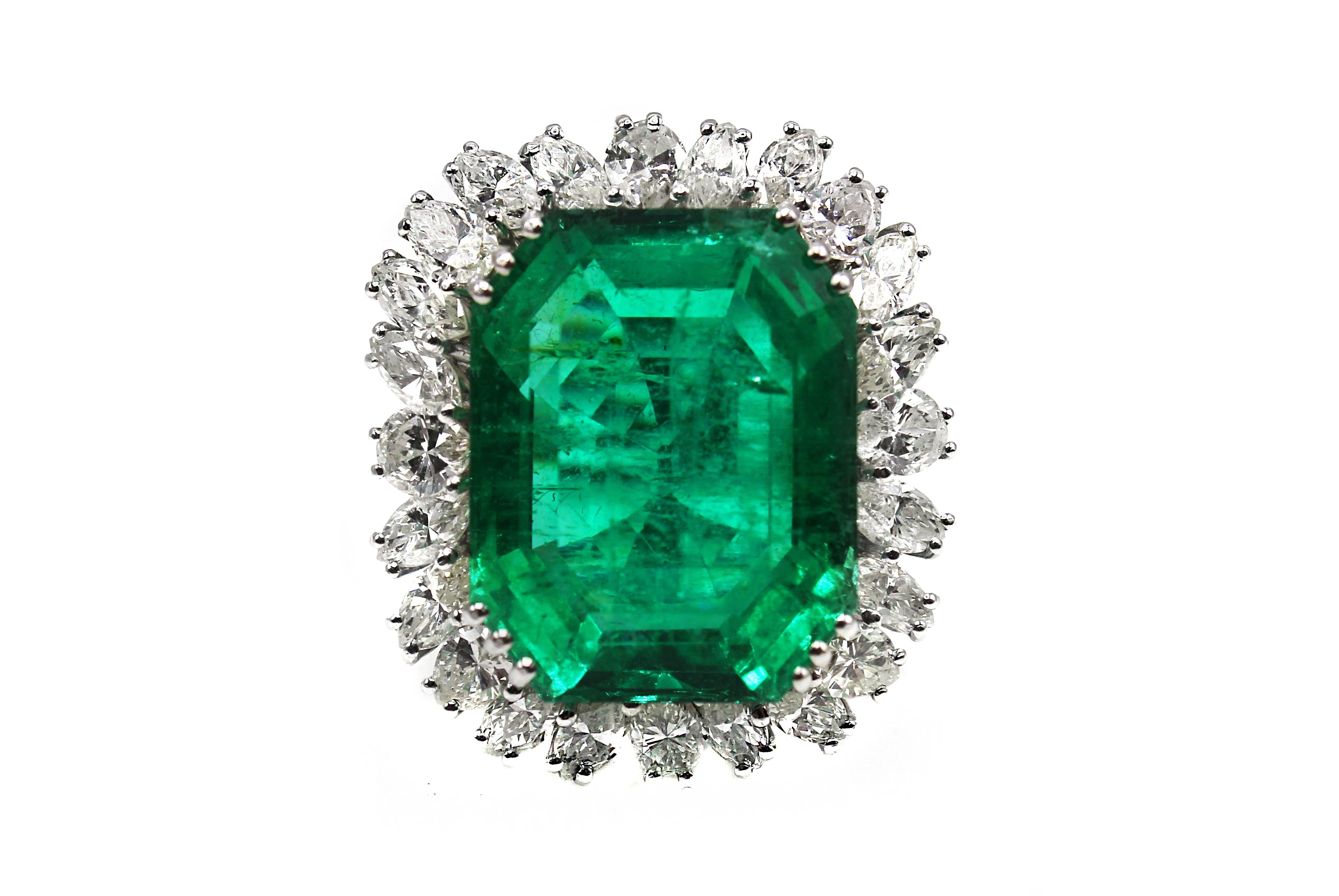 Magnificent Natural Colombian Emerald, weighing approximately 25 carats, set in a custom hand crafted 18 karat white gold mounting. Triple prong set at each corner secure this center gem and it is surrounded by 25 marquise cut and pear shape bright,