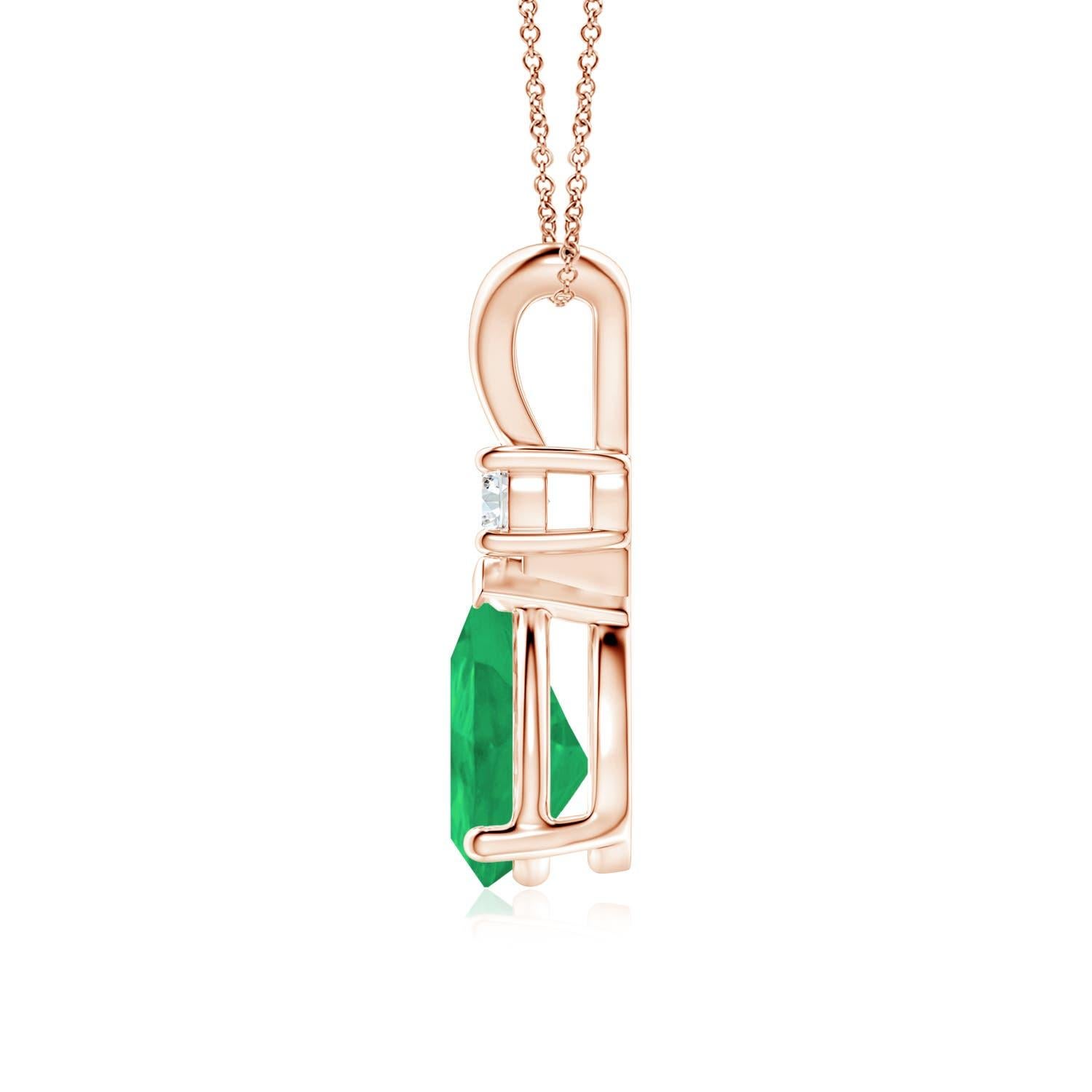 Ce pendentif solitaire classique est orné d'une émeraude en forme de poire, fixée dans un serti clos. Un diamant rond brillant est posé sur la pierre précieuse d'un vert luxuriant, ce qui ajoute à la beauté du design. Simple mais séduisant, ce
