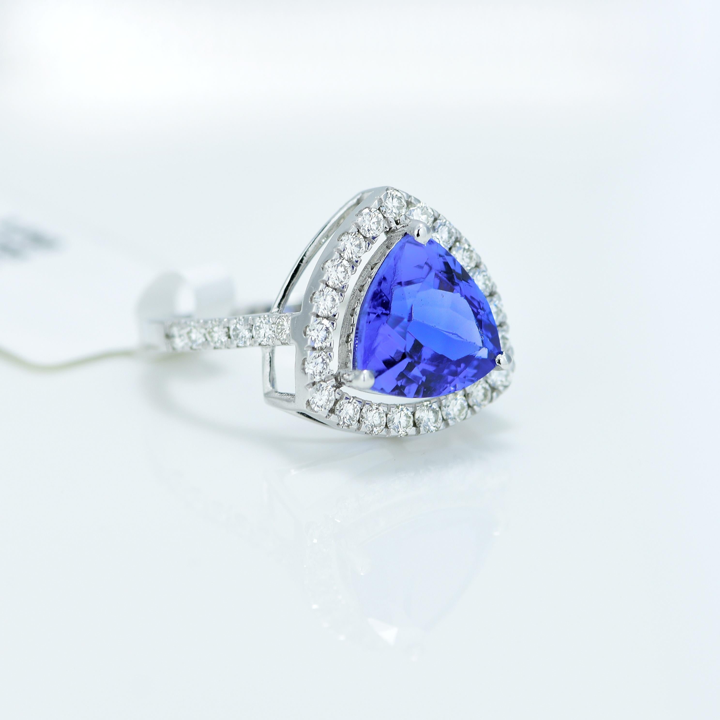 Stunning Violetish Blue Tanzanite and Diamond halo ring.

Centre Stone - Natural Tanzanite, 
Centre Stone Weight - 2.63 Carat, 
Centre Stone Shape & Cut - Triangular Step Cut
 
Total Number of Diamonds - 33, 
Diamonds Carat Weight - 0.56